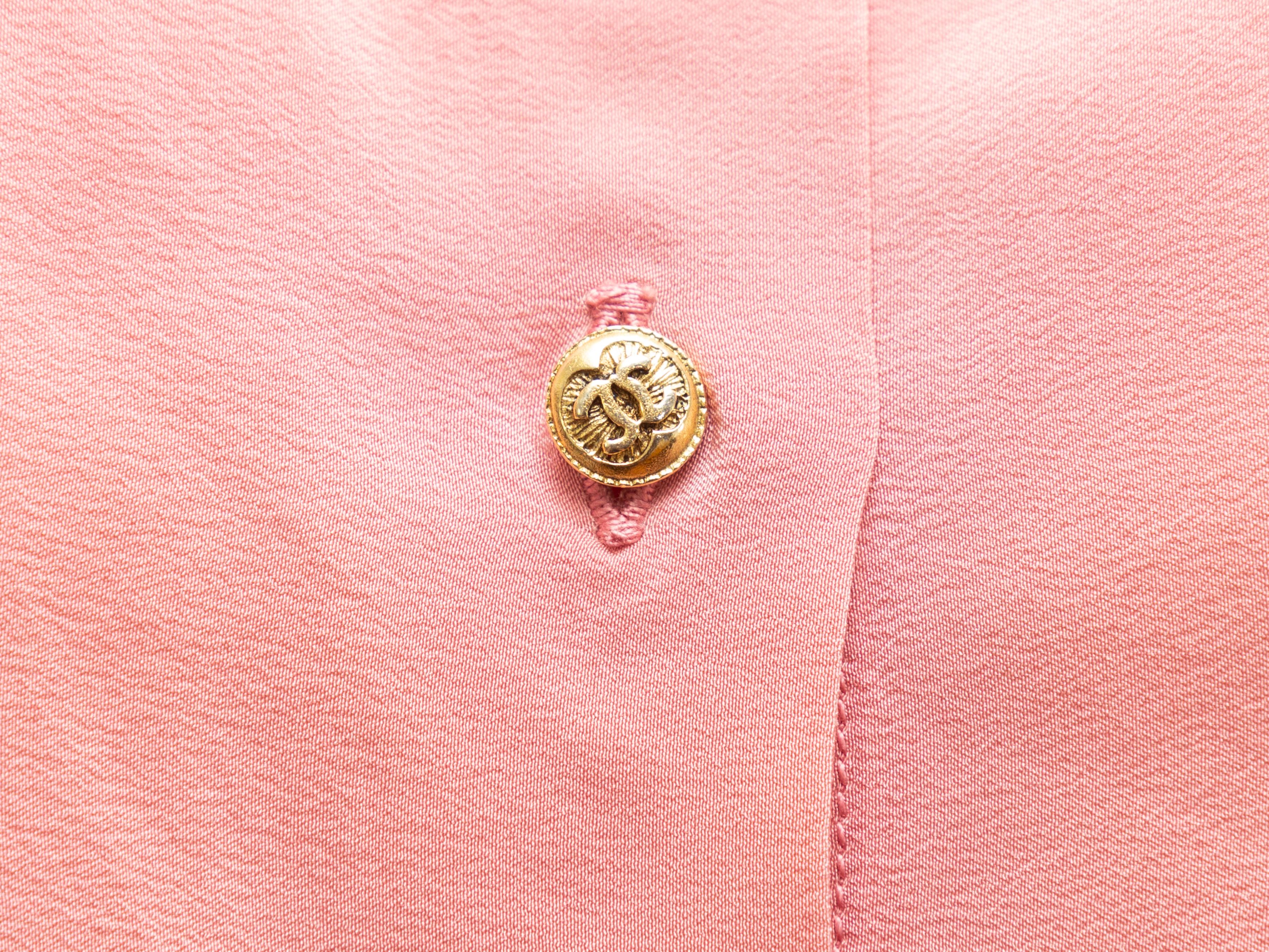 Product details: Vintage pink sleeveless top by Chanel. Pointed collar. Gold-tone CC button closures at center front. 30