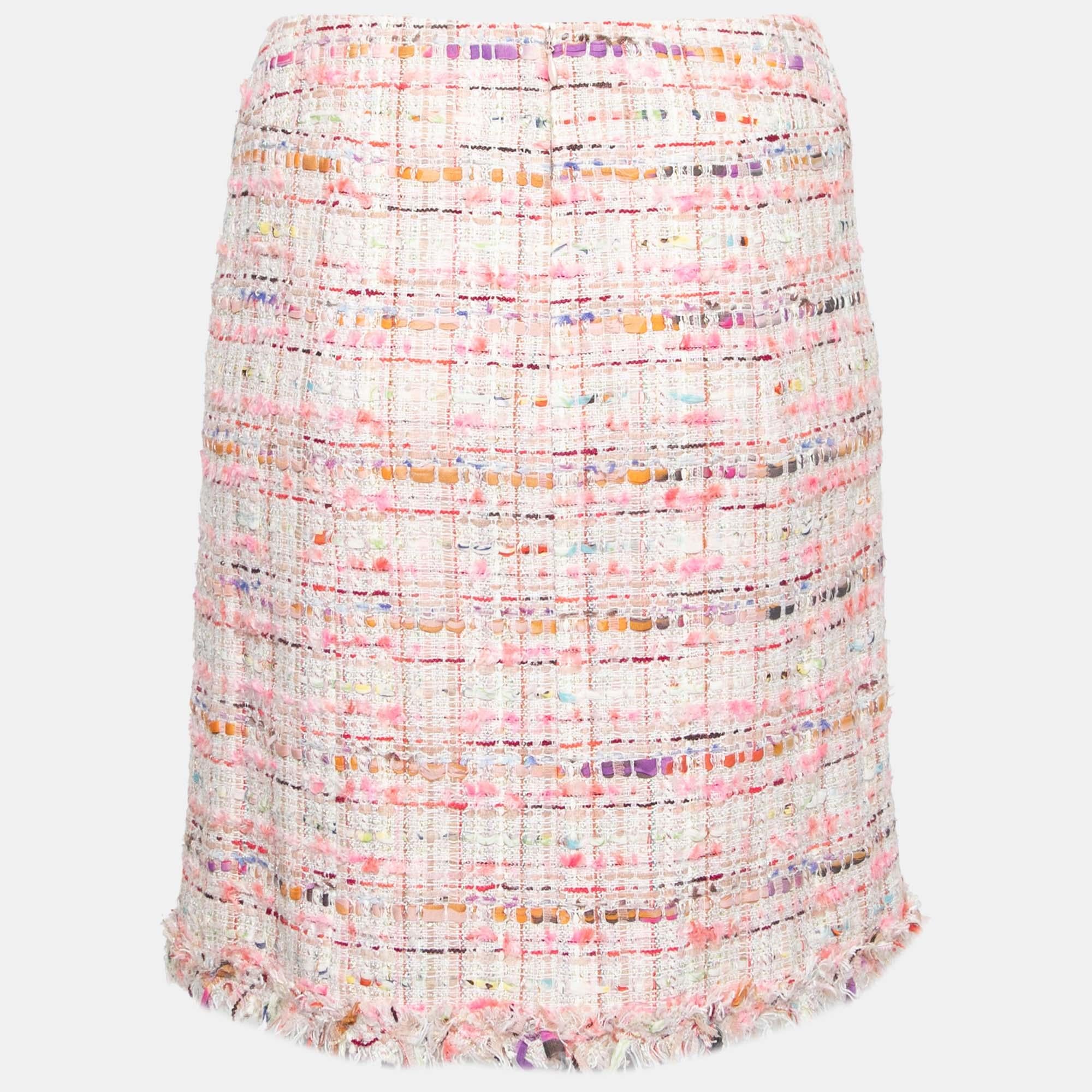 Come fall in love with Chanel's fine sartorial taste and excellence as you wear this stunning skirt. Created from the signature tweed fabric, the beauty of this pink skirt is accentuated with multicolored hues, fringed trims, and a short A-lined