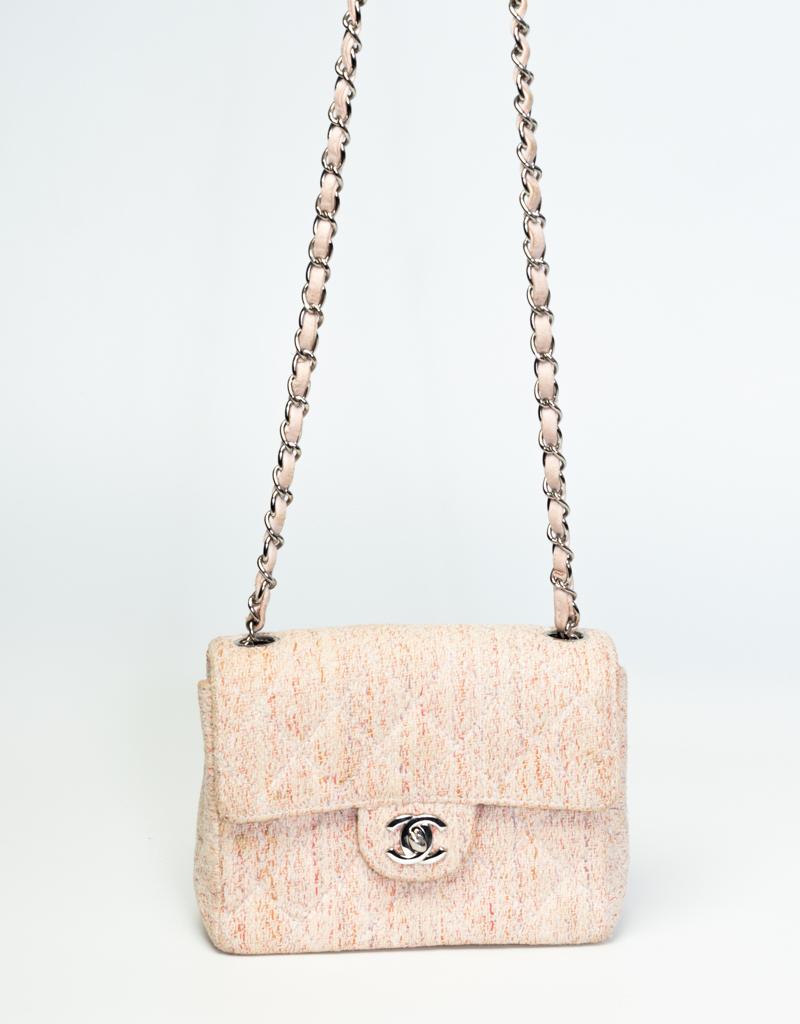 This vintage Chanel Mini Flap Bag is constructed in soft-pink timeless tweed. It’s outfitted with silver tone hardware, a front flap with the signature interlocking CC turn lock closure, a silver toned chain strap interlaced with leather, an