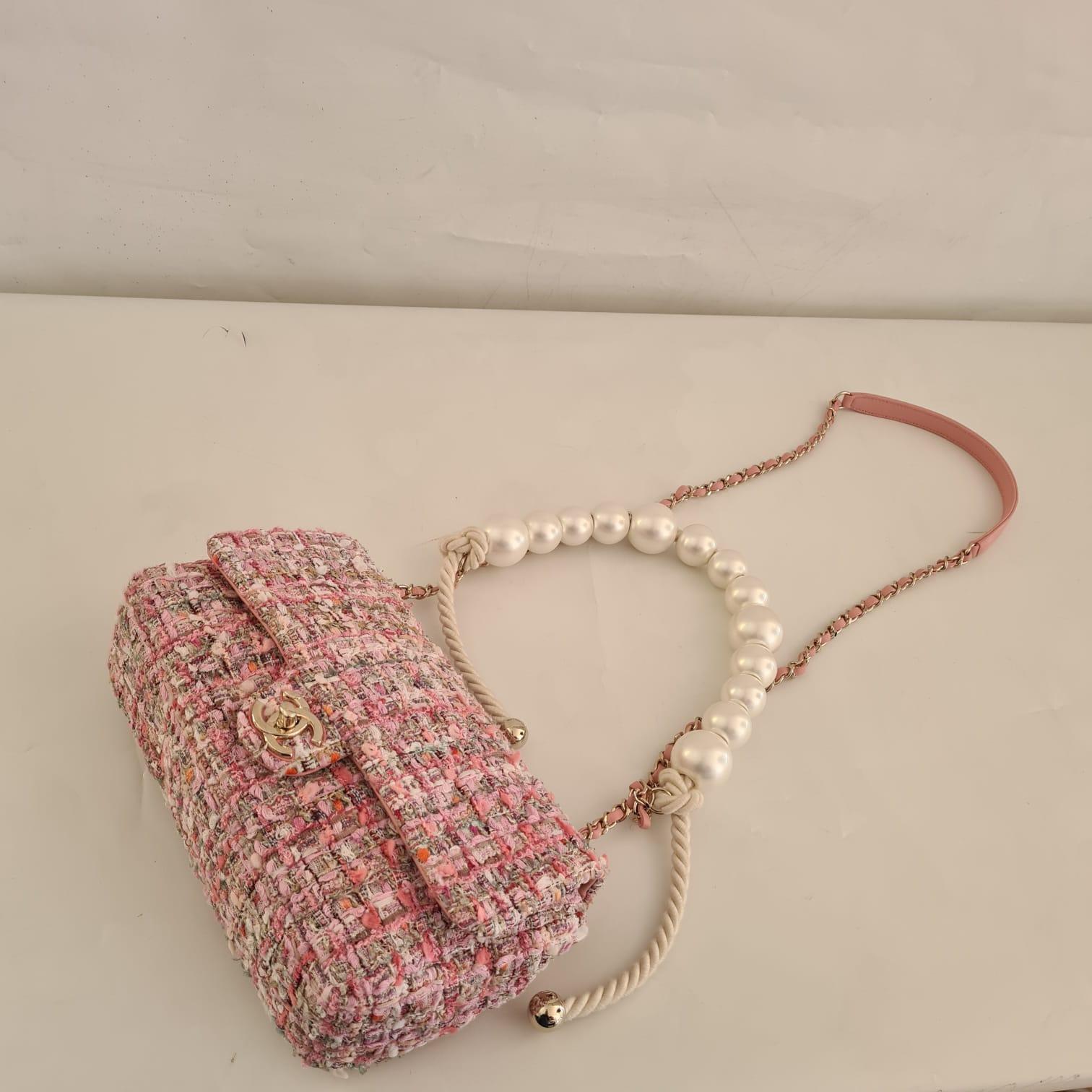 A rare pink tweed flap bag with pearl handle from the by the sea collection. Light pulling on the tweed body but nothing major. Light rubbing on the corners. Pearl details are still in beautiful condition. Series #28. Comes with its card, dust bag