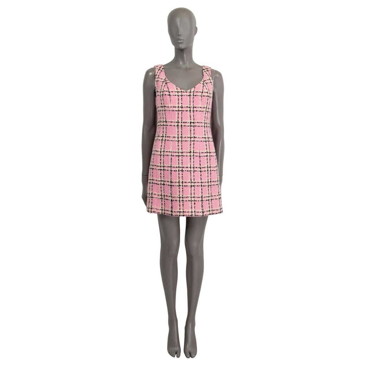 100% authentic Chanel sleeveless tweed mini dress in pink, black and off-white wool (assumed cause tag is missing). Opens with a zipper and a hook on the back. Lined in pink silk (assumed cause tag is missing). Shows deodorant stains on the outside