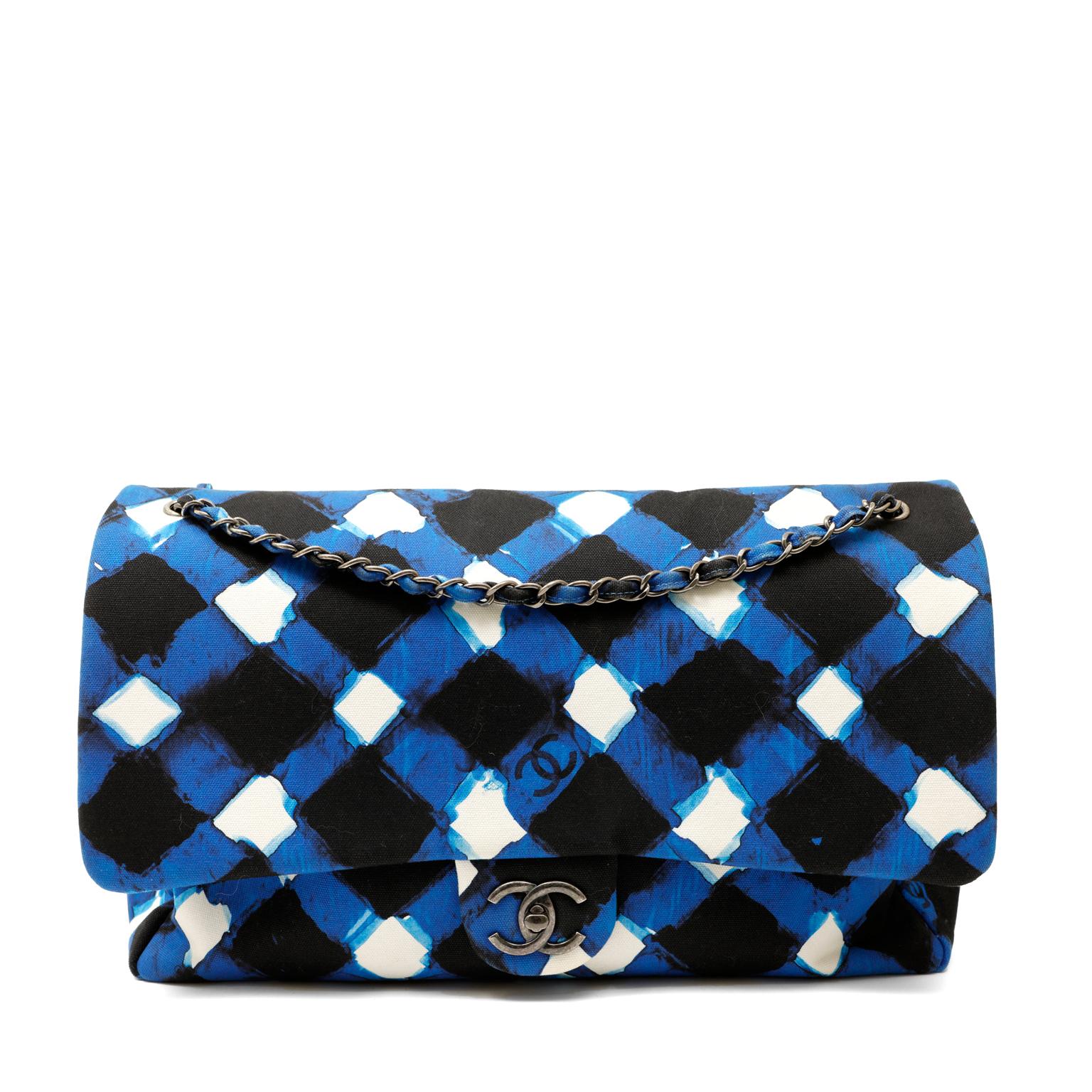 This authentic Chanel Plaid Airline Travel Canvas Flap Bag is a runway piece in pristine condition.  The extra-large silhouette paired with blue plaid printed canvas makes this Chanel especially collectible.  
Plaid treated canvas in cobalt blue,