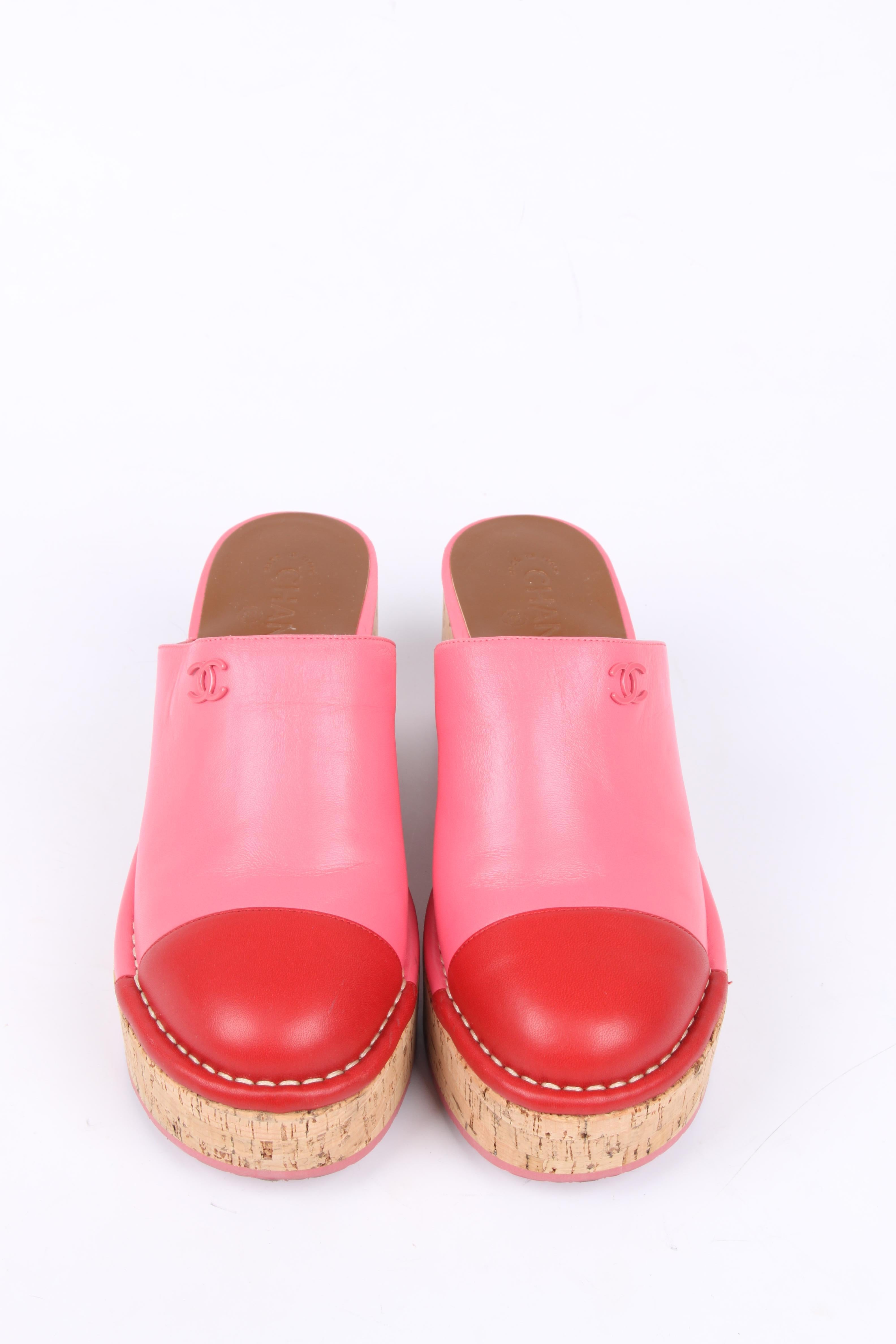 Cheerful mules by Chanel in red and pink leather.

The sole is made of cork, the heel measures 8 centimeters and the platform is 3,5 centimeters high. The cap toe is crafted from red leather and the rest is executed in pink leather. 

Both shoes are