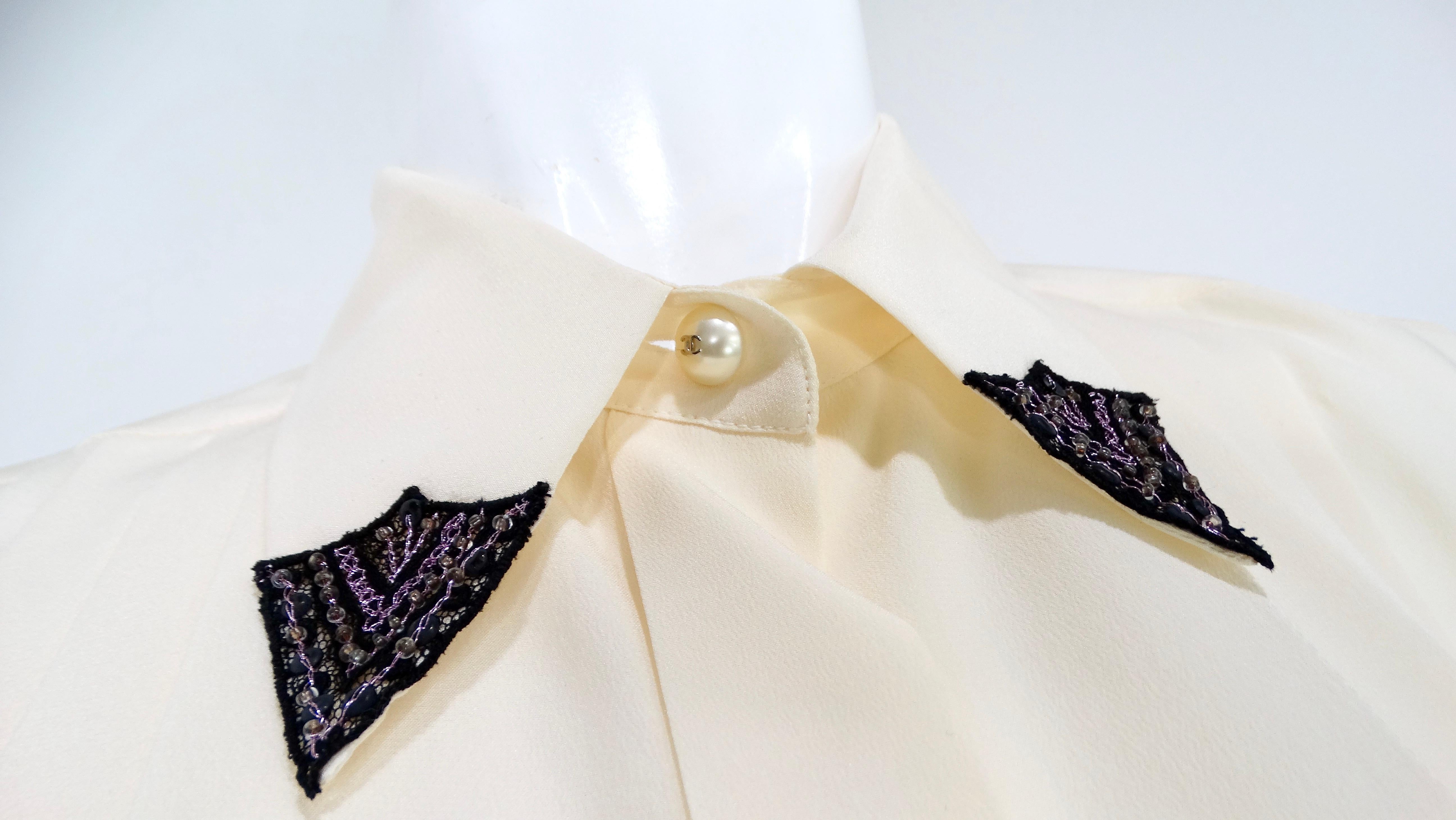 The Chanel Pleated Cream Silk Blouse with Beaded Lace Accents from circa 2002 is a timeless piece that exemplifies elegance and sophisticated craftsmanship. Crafted from luxurious cream silk, the blouse features delicate pleats that add texture and