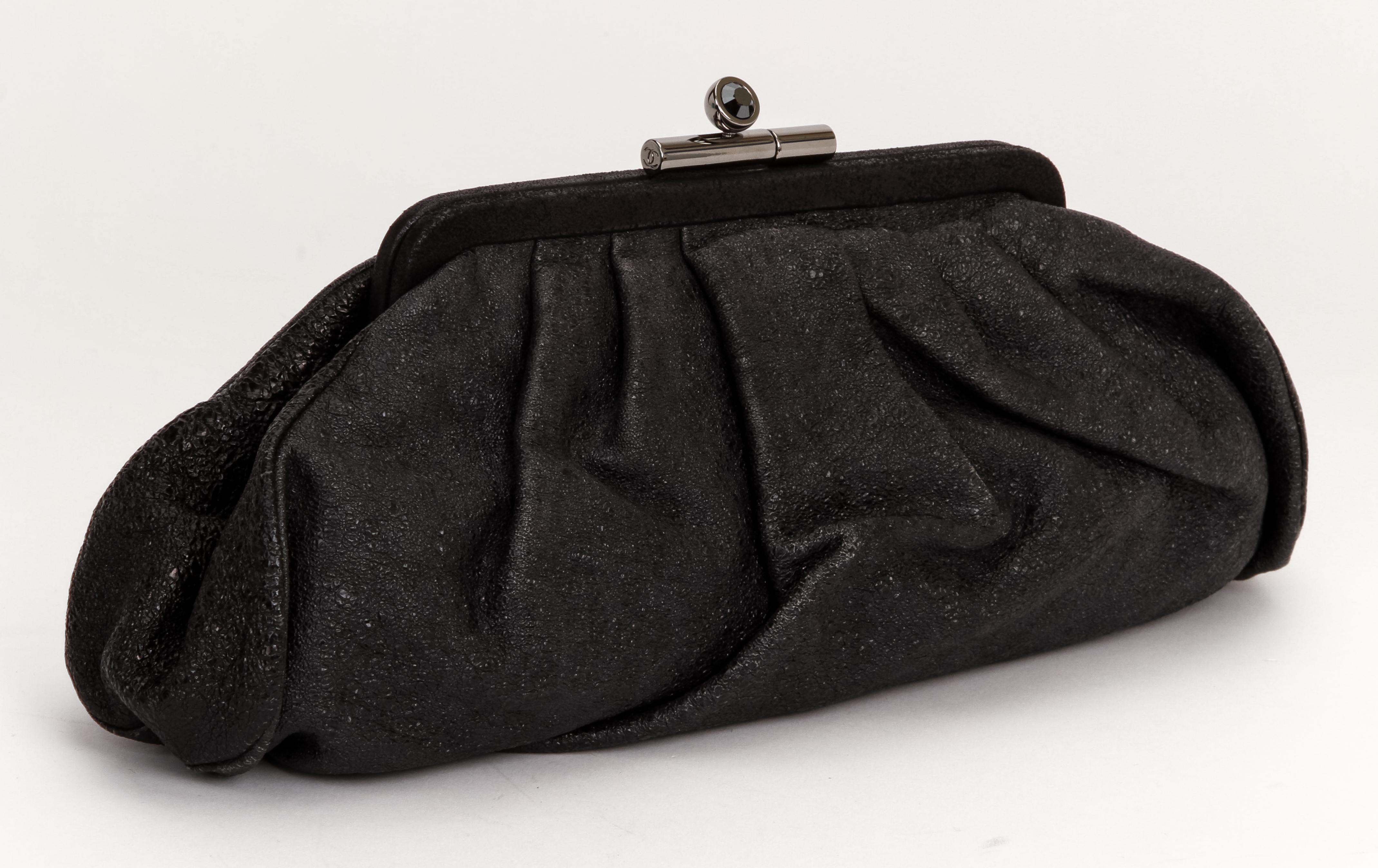 Riding the wave of the 2020 pleated soft clutches, this beautiful Chanel lambskin leather clutch in black is the perfect evening bag. The buckle shows a crystal and the logo and it closes the complete bag. It comes with the original Chanel dust bag