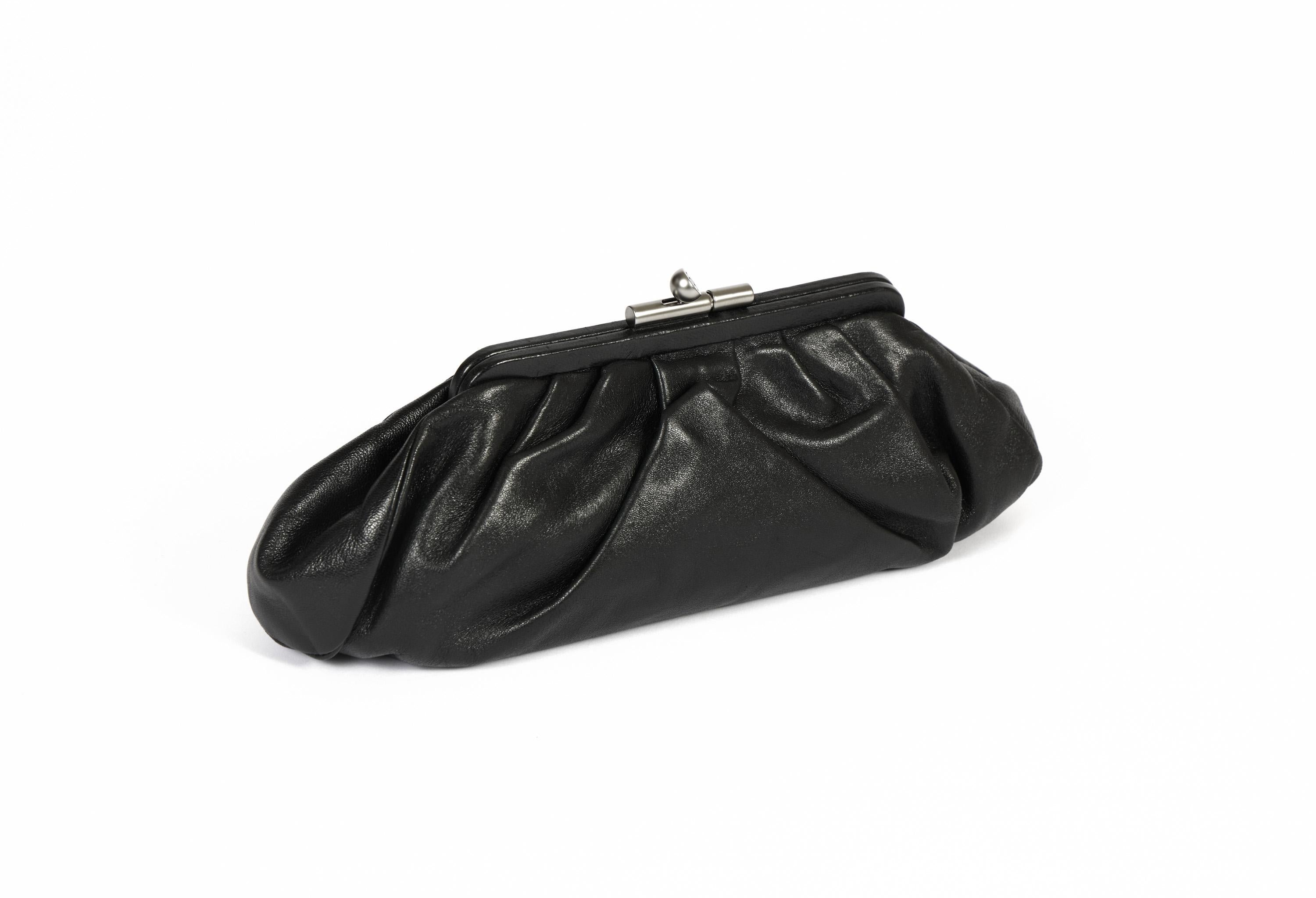 Riding the wave of the 2020 pleated soft clutches, this beautiful Chanel lambskin leather clutch in black is the perfect evening bag. The buckle shows a the logo and it closes the complete bag. It comes with the original Chanel dust bag and