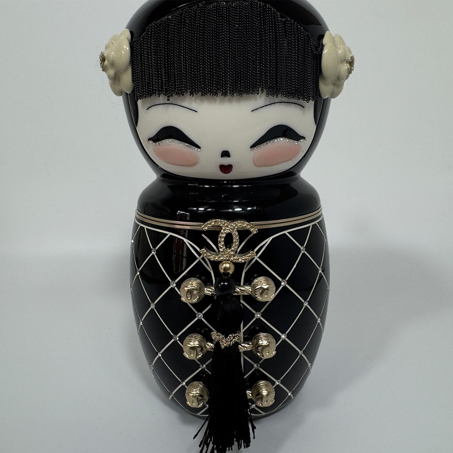 Descubre el encantador encanto de la Mu�ñeca China Chanel París-Shanghai, una pieza de edición limitada que combina capricho y lujo. Presentado por primera vez en la pasarela de 2011, este bolso altamente coleccionable está ahora disponible en