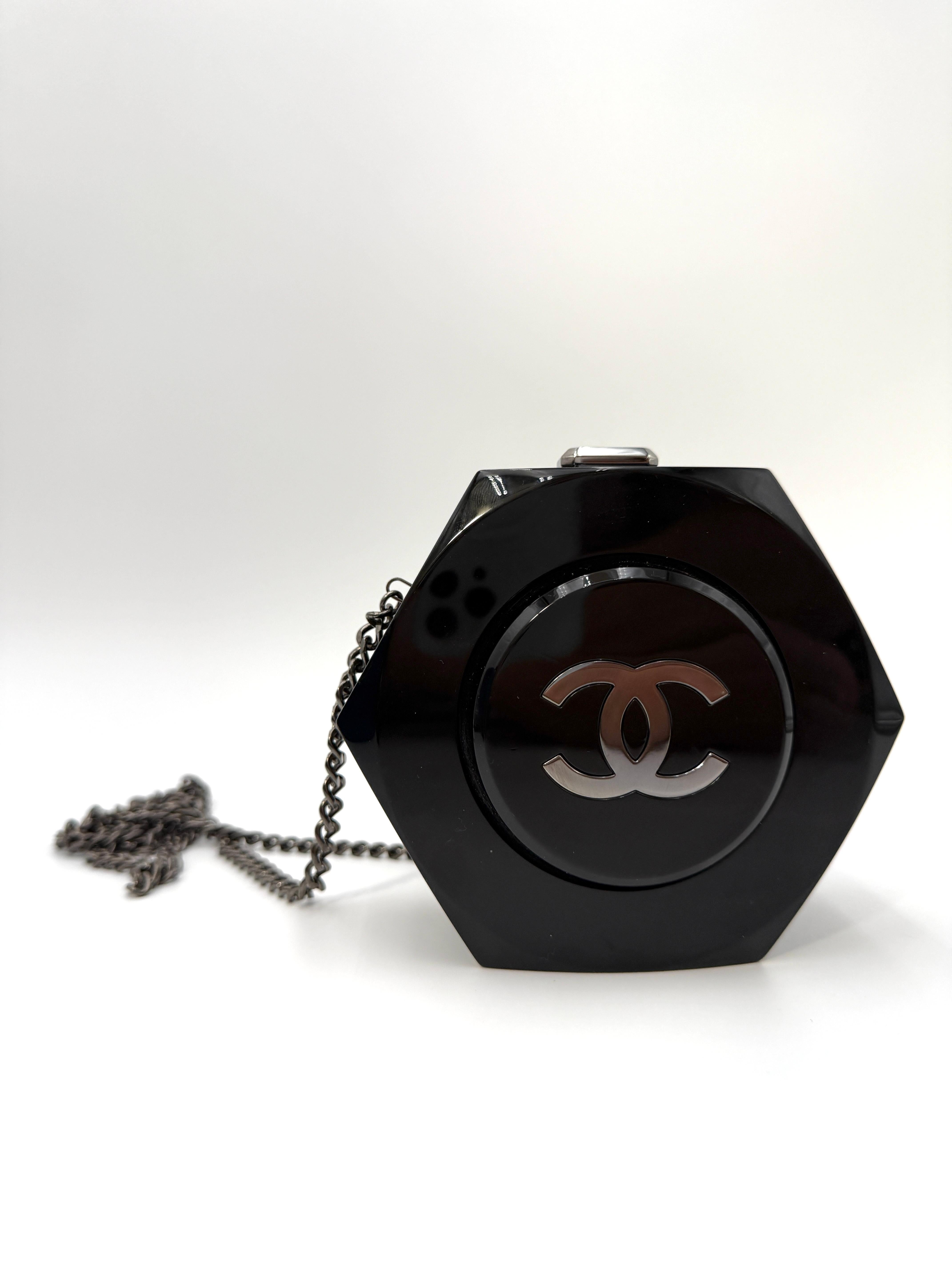 Cette minaudière de Chanel, rare et de collection, de forme octogonale, est fabriquée en plexiglas noir brillant et arbore le logo CC emblématique en argent sur le devant. Il présente une silhouette structurée avec une fermeture à charnière sur le