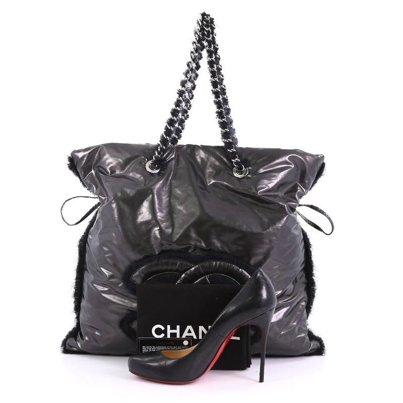 This Chanel Polar Bon Bon Tote Vinyl with Mohair, crafted from black vinyl with mohair, features woven-in mohair chain link straps, exterior back slip pocket, and silver-tone hardware. Its magnetic snap button closure opens to a gray satin interior