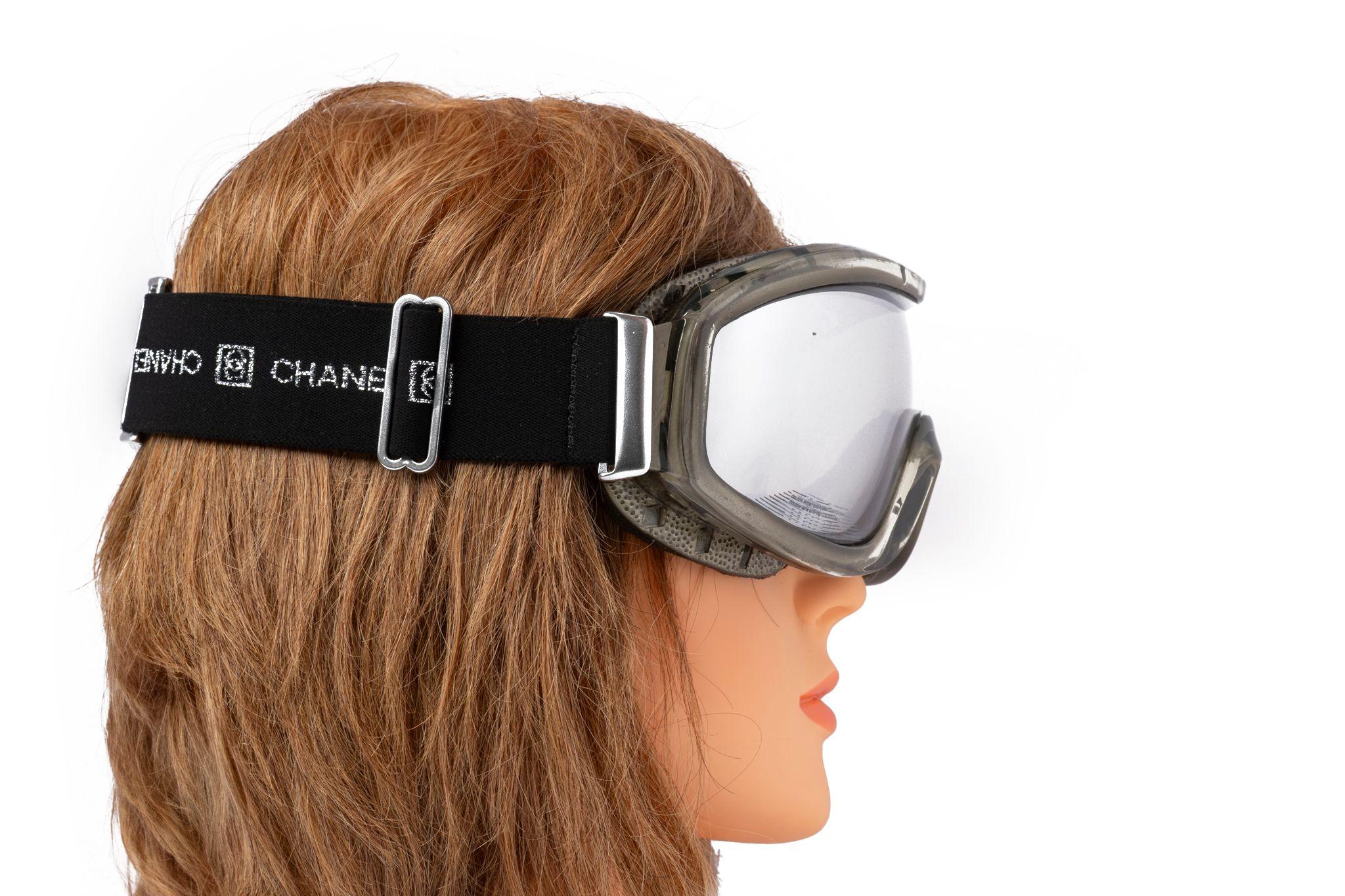 La maschera da sci polarizzata Chanel by Karl Lagerfeld for Chanel è caratterizzata da doppie lenti polarizzate con finiture in gomma e antiappannamento, interno in schiuma e fessure inferiori traforate, fascia elastica regolabile, fibbie