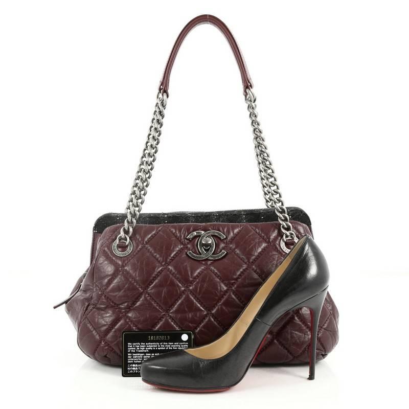 This authentic Chanel Portobello Bowler Bag Quilted Aged Calfskin and Tweed Medium is a luxurious bag perfect for everyday use. Crafted from quilted dark burgundy aged calfskin leather and black tweed, this bag features dual chain-link shoulder