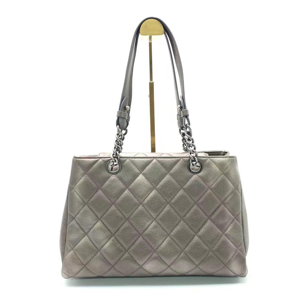 Chanel Portobello ChainTote Bag Bronze Metallic Silver Calfskin
 These are professional photos of the actual bag offered by Luxbags.
 Elevate your style with the Chanel Portobello Tote Bag. Crafted in metallic quilted calfskin leather with dark