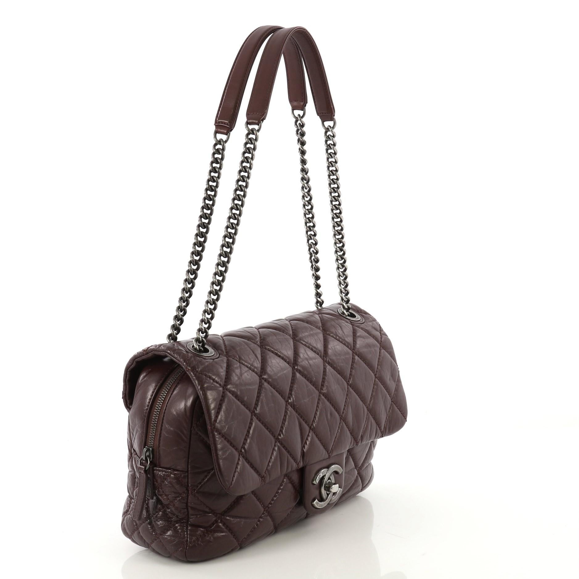 This Chanel Portobello Flap Bag Quilted Aged Calfskin Jumbo, crafted from burgundy quilted aged calfskin leather, features chain link straps with leather pads and aged silver-tone hardware. Its CC boy push-lock closure opens to a burgundy fabric