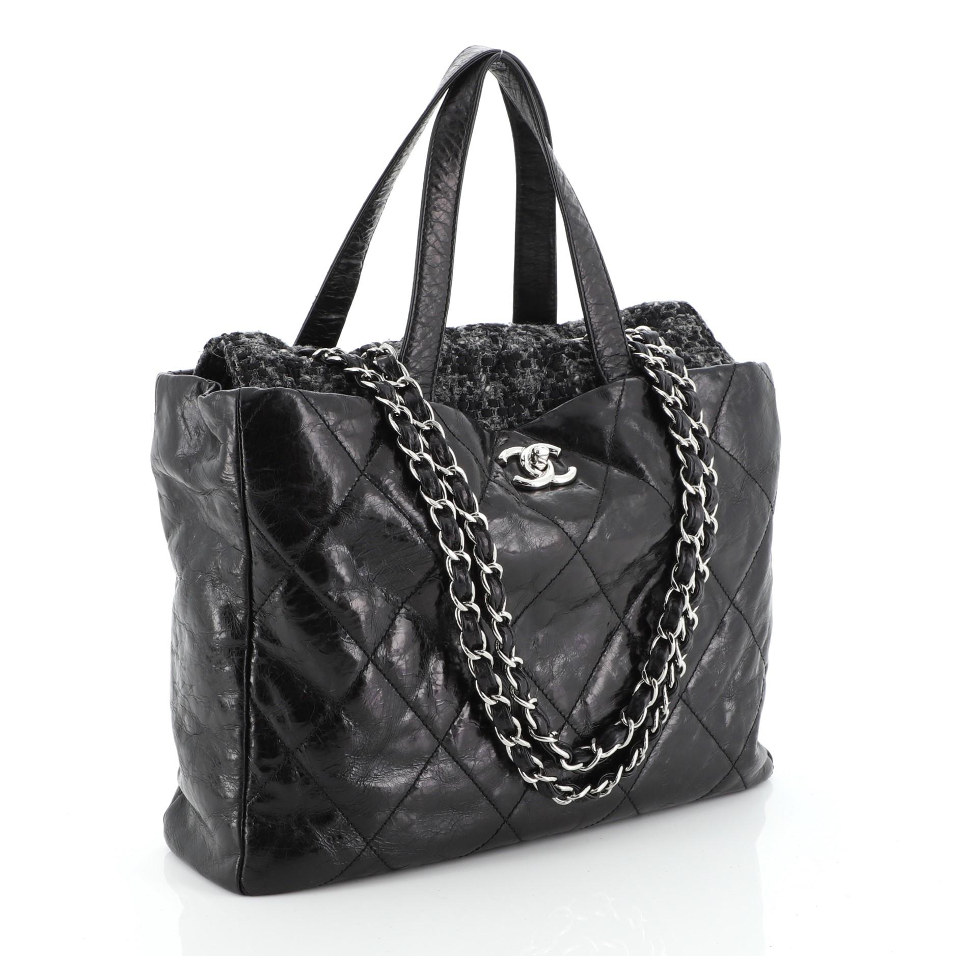 This Chanel Portobello Tote Quilted Glazed Calfskin and Tweed Medium, crafted in black quilted glazed calfskin and tweed, features dual leather handles, woven-in leather chain link straps, and silver-tone hardware. Its CC turn-lock closure opens to