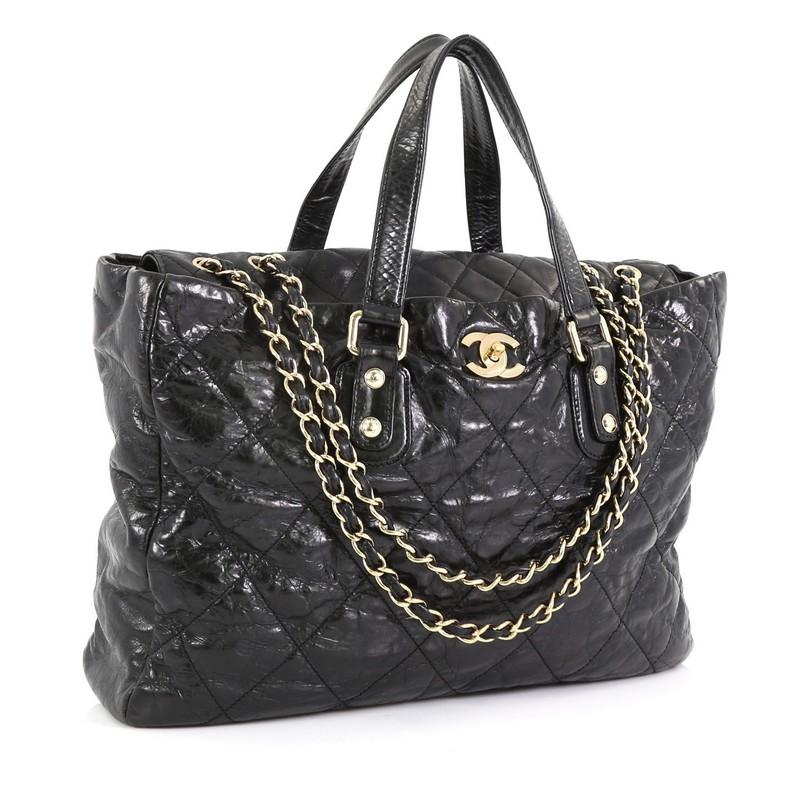 This Chanel Portobello Tote Quilted Glazed Calfskin Large, crafted from black glazed calfskin, features dual flat leather handles, protective base studs and gold-tone hardware. Its turn-lock closure opens to a gray fabric interior with zip and slip