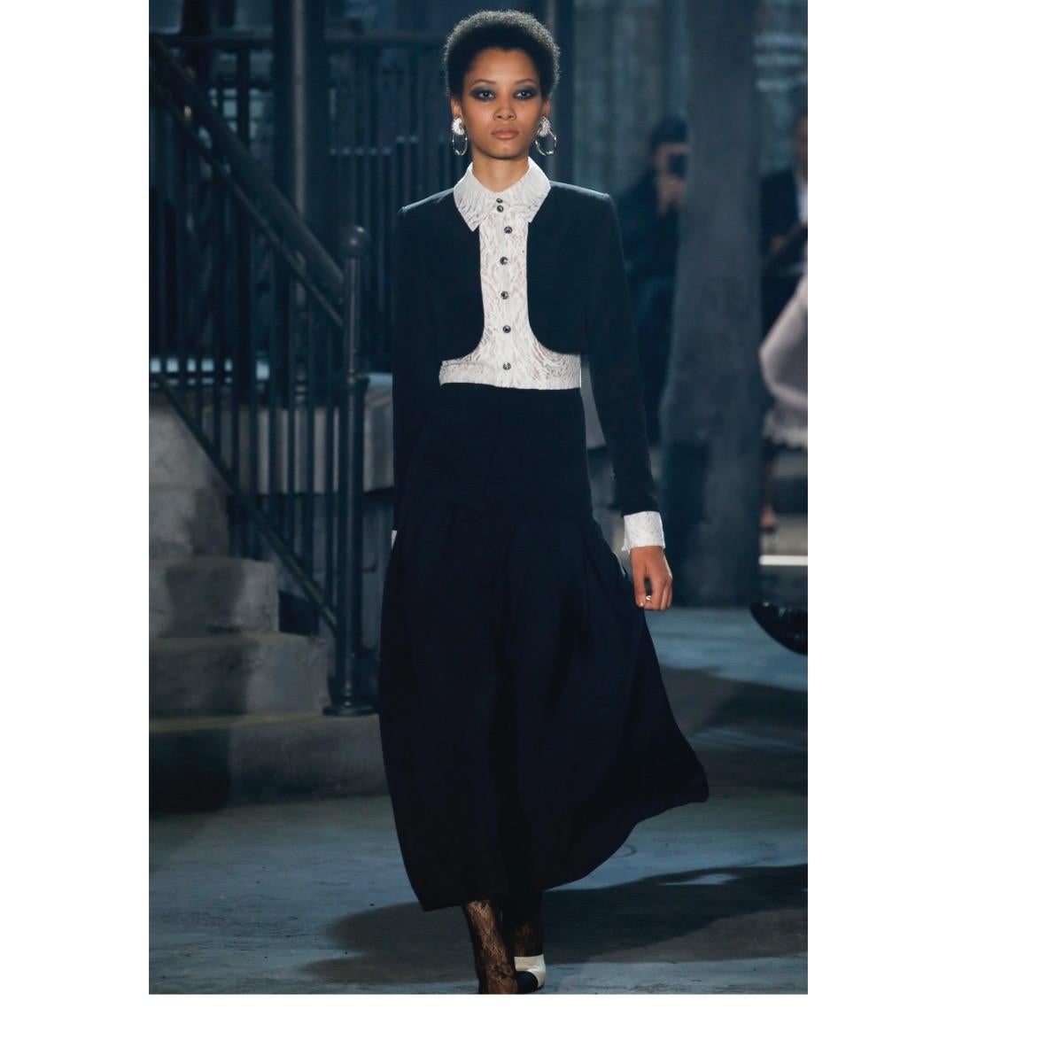 CHANEL
Collection Pre-fall 2016 Paris-Rome
Long black silk and white lace dress with lace and jewels buttons.
Long black silk sleeves with white lace cuffs, zip fastening
Front fastening with jewel buttons and hidden zip.
Upper part in white lace