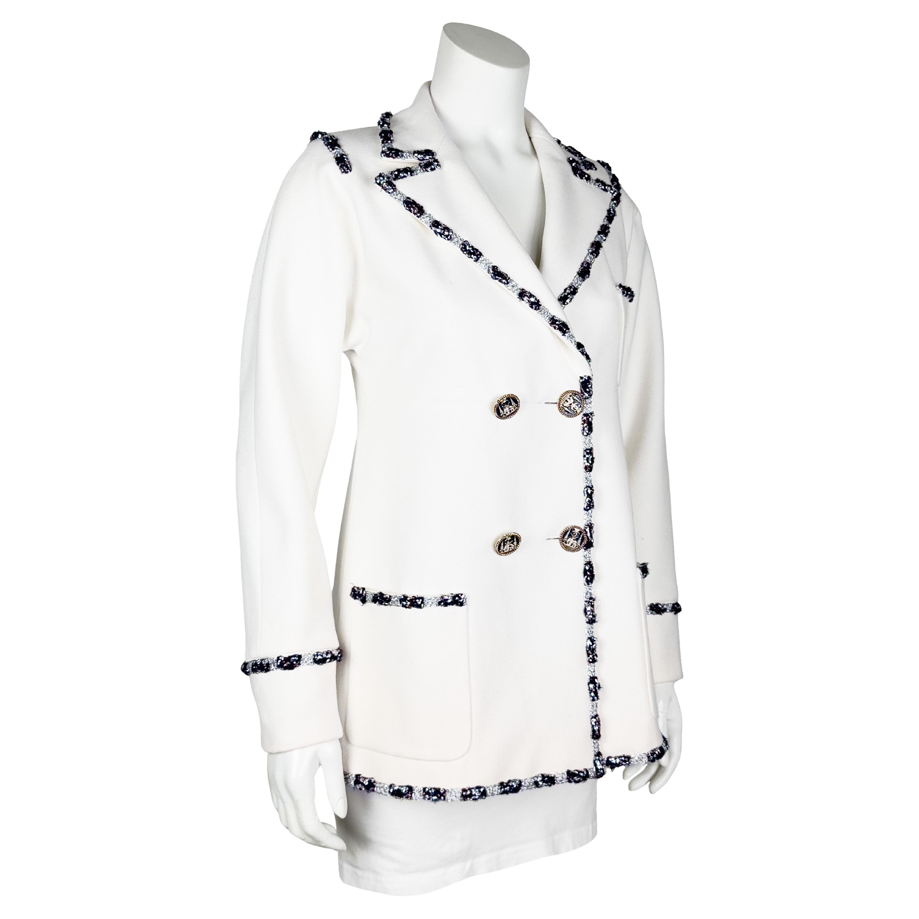 Chanel Pre Autunno 2012 Parigi-Bombay in misto cashmere bianco sporco  giacca doppiopetto con rifiniture in nero e filo metallico. Bottoni in argento e smalto con elefanti e templi che evidenziano i simboli indiani. Stemma ricamato e con perline a