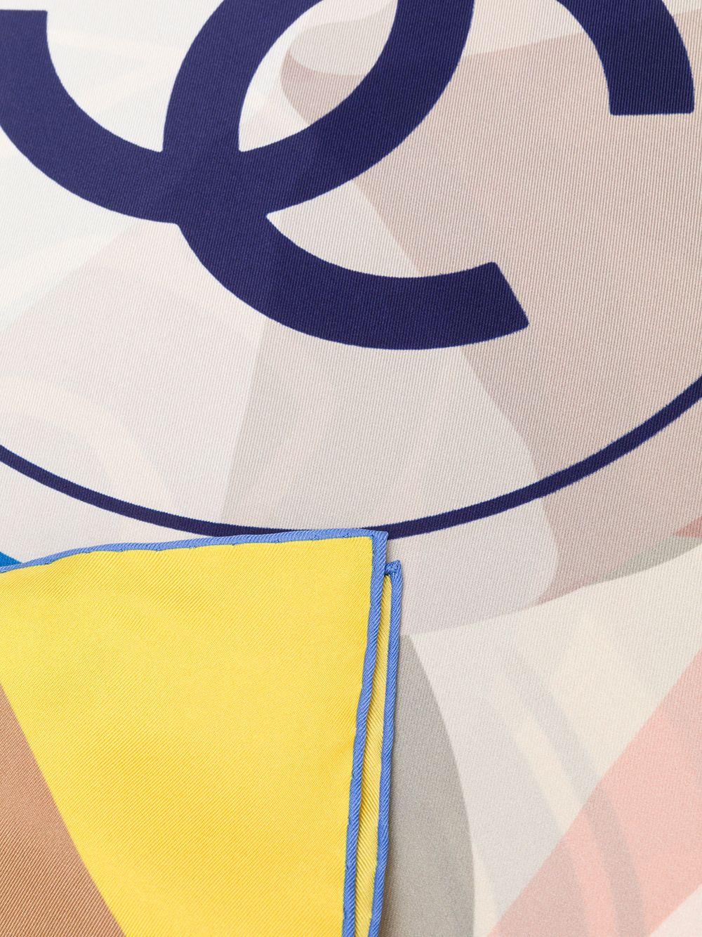 Este pañuelo vintage de Chanel, confeccionado en Italia con la más pura seda de color azul marino, presenta un motivo estampado gráfico central 