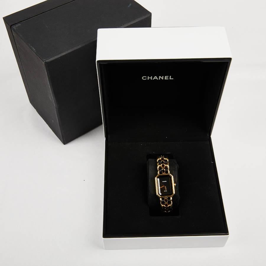 Iconic CHANEL watch Première gold plated interlaced chain of black leather. The leather braiding is reminiscent of the belts and chains CHANEL bags of the 80s. Micro-scratches on the metal. It is in perfect condition. The watch has been completely