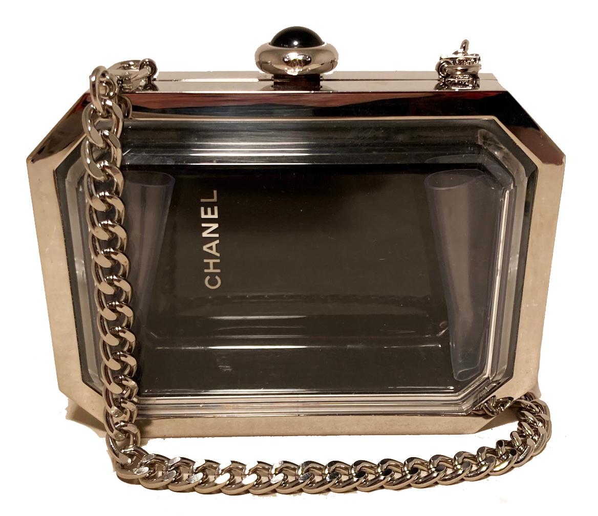 Rare limited edition Chanel Premiere Plexiglass Watch Minaudiere in excellent condition. Silver tone hardware base with clear plexiglass front and black back in signature timeless watch minaudiere shape. Top button closure opens to a black and clear