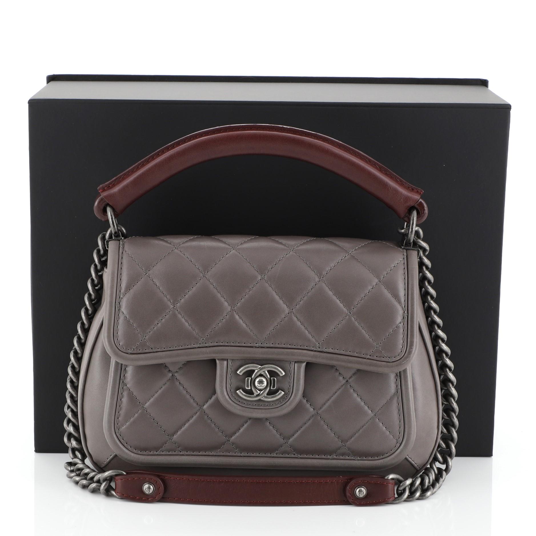This Chanel Prestige Flap Bag Quilted Calfskin Medium, crafted in gray quilted calfskin leather, features a sturdy leather top handle, chain-link shoulder strap with shoulder pad, CC press lock closure and aged silver-tone hardware. Its press-lock