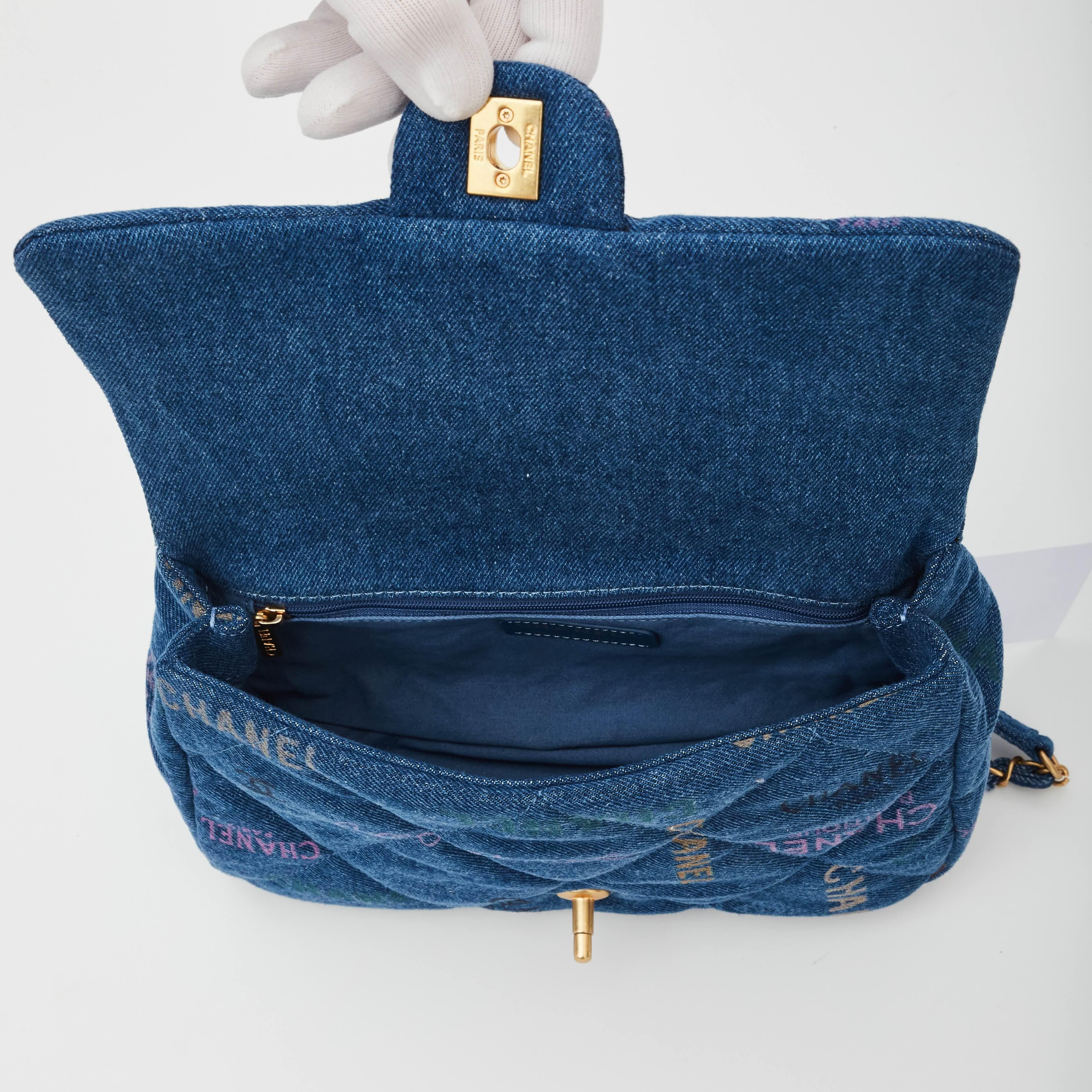 This flap bag is made from blue denim. The bag features a crossbody canvas threaded shiny gold chain shoulder strap. It also features a graffiti CC motif, and shiny gold Chanel CC turn lock that opens the flap to a matching fabric interior with a
