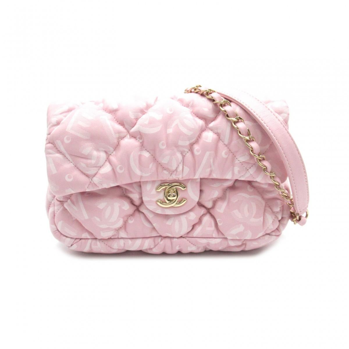 This Chanel shoulder bag is constructed of soft quilted lambskin leather with the Chanel name and logo printed throughout the exterior. The bag features light gold metal, a metal and pink lambskin threaded shoulder strap and a classic CC turn lock