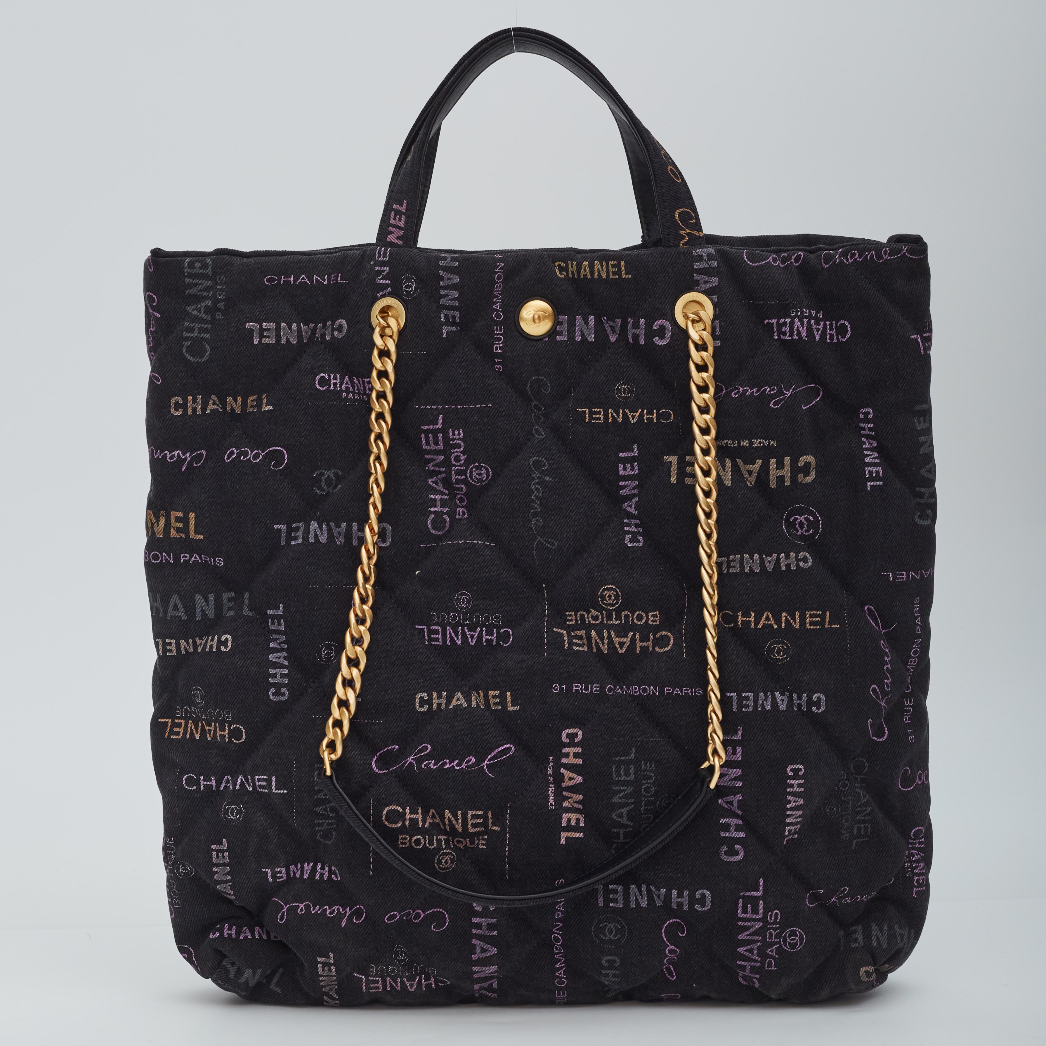 This flap bag is made from black denim. The bag features dual flat leather top handles, chain shoulder strap, gold tone hardware, graffiti CC motifs, CC turn lock closure and a matching fabric interior with a pocket.

Color: Black
Material: