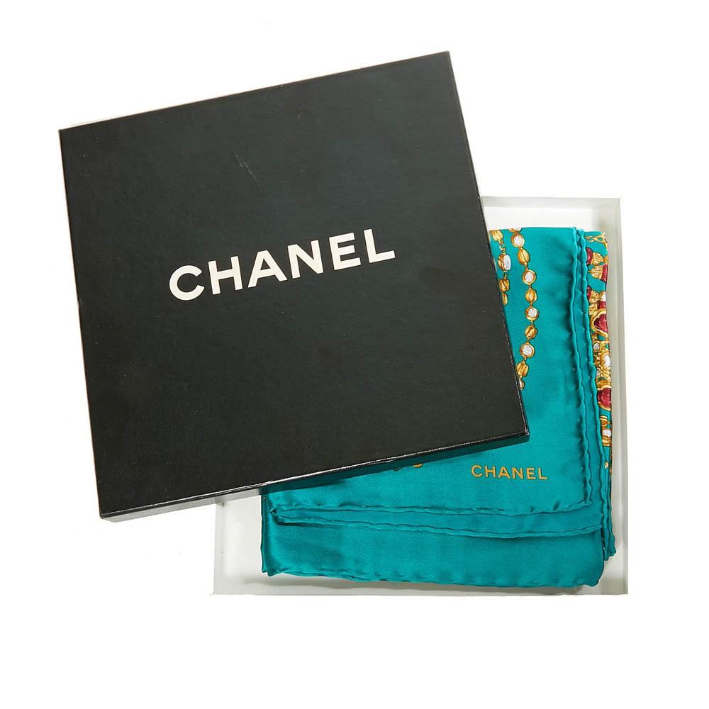 CHANEL scarf with printed pearl necklace, on green silk, in very good condition (just the label of material is missing). The roulotte is impeccable.
CHANEL inscription in the corner. 90 x 90 cm. 
This CHANEL scarf will be delivered in its original