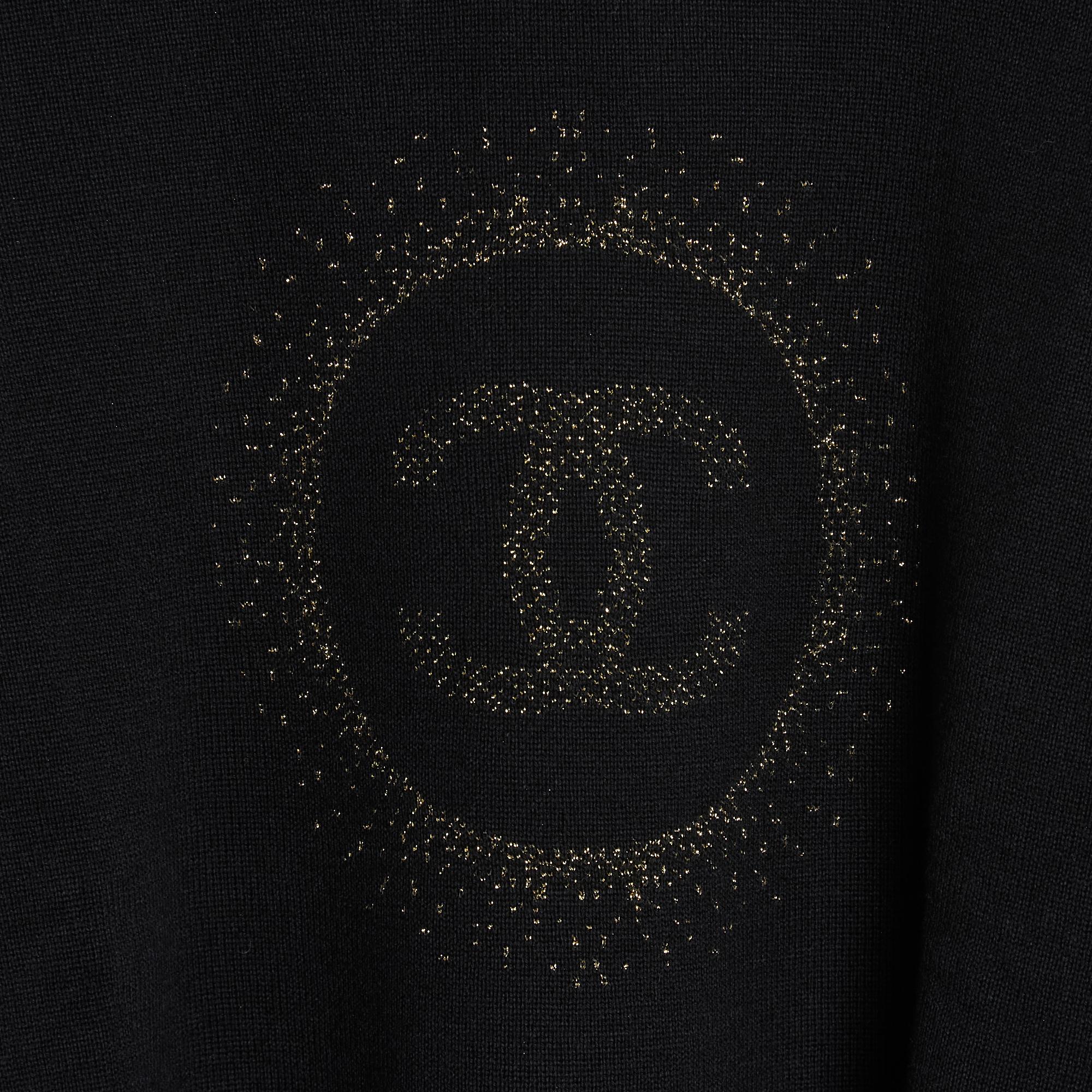 Chanel Uniform oversized volume, cropped sweater, in black wool and cotton knit decorated with a large central CC logo in gold lurex jacquard surrounded by a halo, round neck, long sleeves, 2 slits on the sides. Size M or 38FR or UK10 or US8: