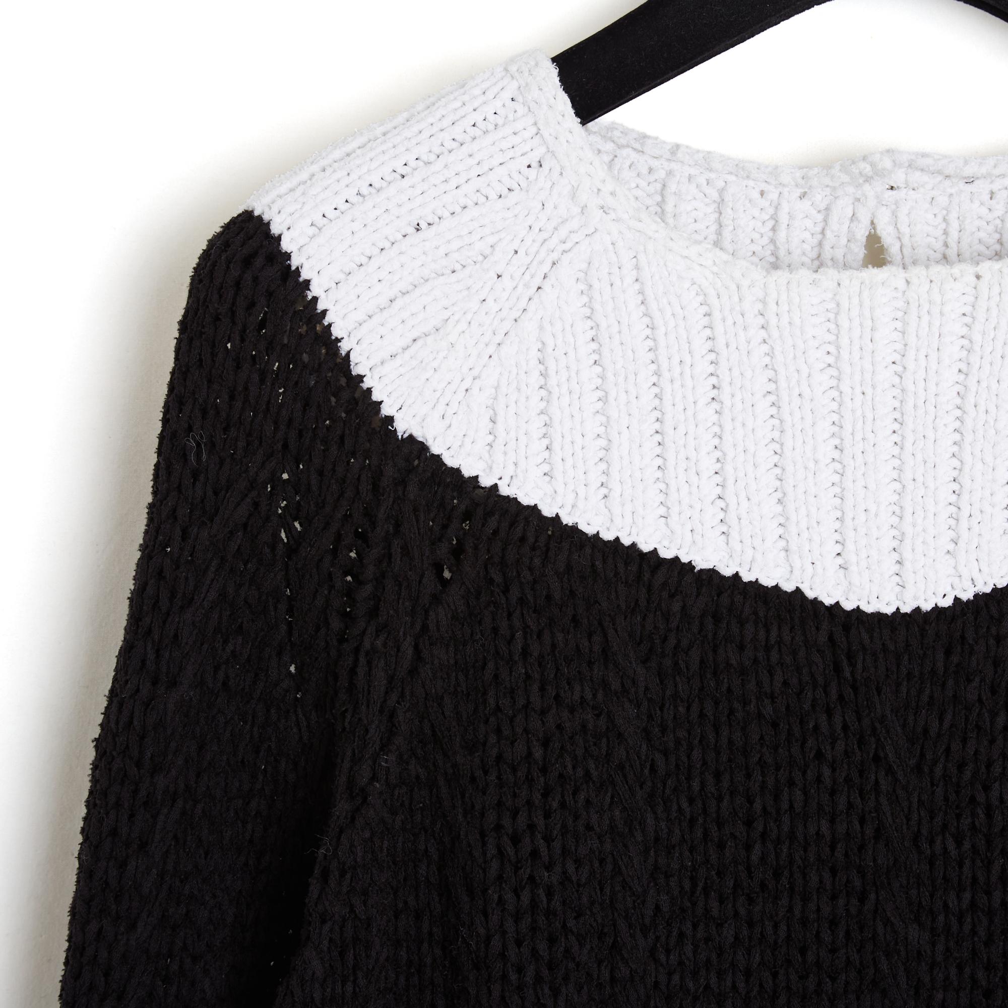 Top Chanel sweater in thick black soft cotton knit with white ribbed edges, wide and short cut, round neck closed by a button with logo in the back, 2/3 sleeves, unlined. No more size label but the measurements indicate a 38Fr: shoulders 38 cm,