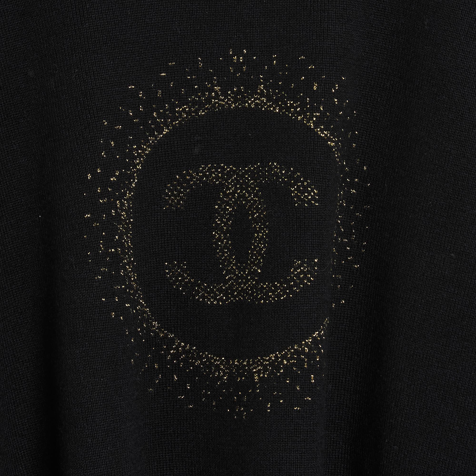 Chanel Uniform sweater, oversize volume, cropped, in black wool and cotton knit decorated with a large central CC logo in gold lurex jacquard surrounded by a halo, round neck, long sleeves, 2 slits on the sides. Size XXXL is 46FR or UK18 or US16 but