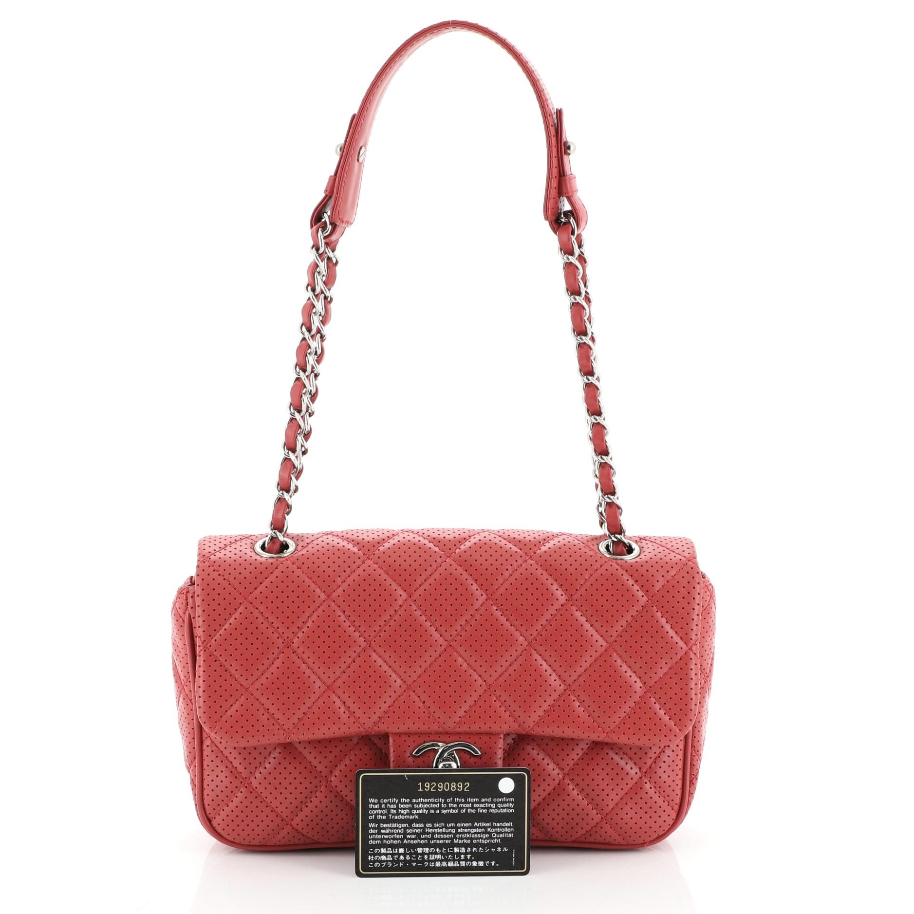This Chanel Punch Flap Bag Quilted Perforated Lambskin Medium, crafted in red quilted perforated leather, features woven-in leather chain strap, exterior back pocket and gunmetal-tone hardware. Its turn-lock closure opens to a neutral fabric