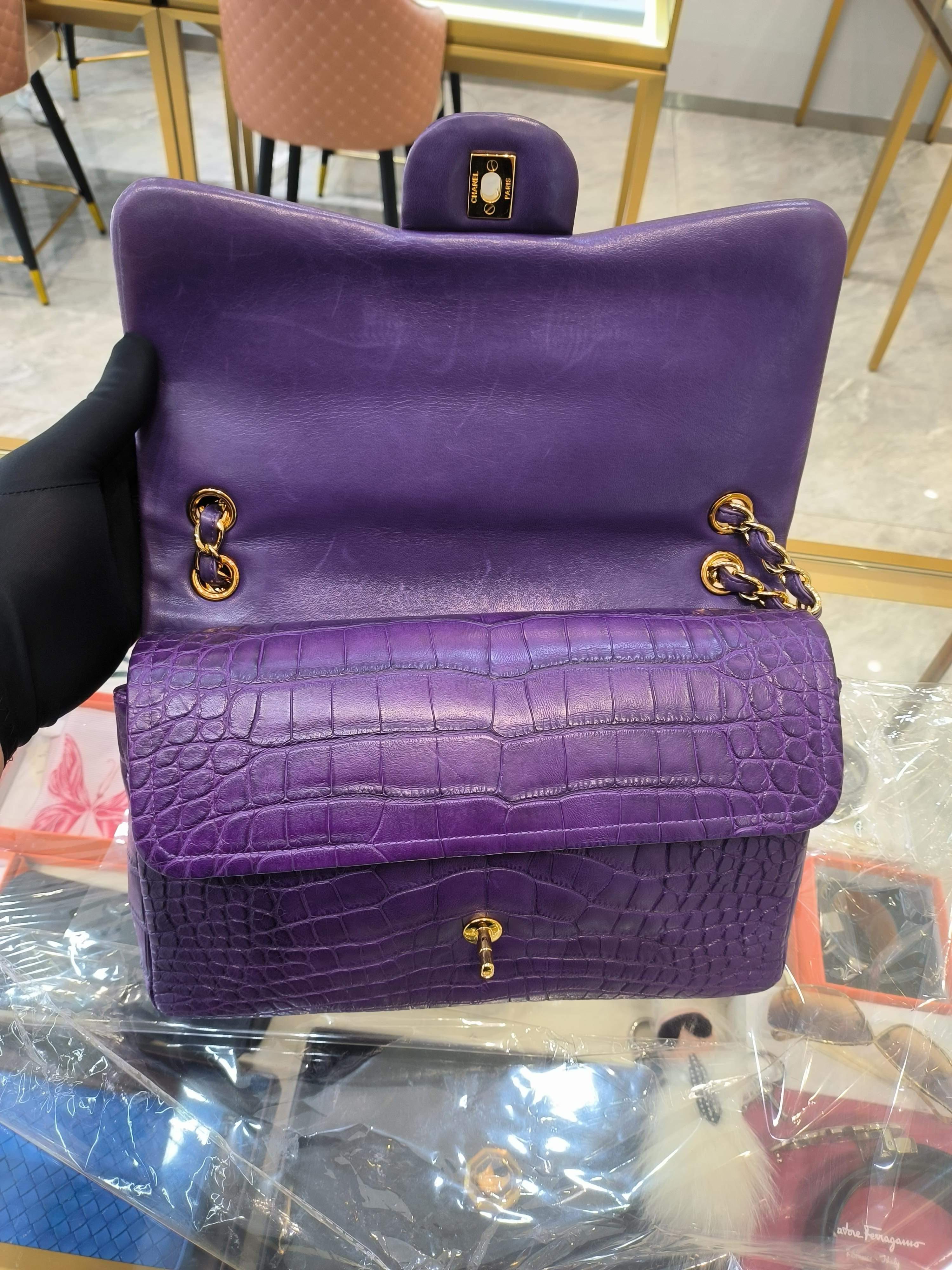 AN EXQUISITE JUMBO CHANEL PURPLE CROCODILE CLASSIC FLAP BAG WITH GOLD TONE HARDWARE CHANEL, 2013-2014 Year.
Crafted with precision using rare alligator leather, and touched with a fabulous purple color, this Classic Double Flap bag from Chanel