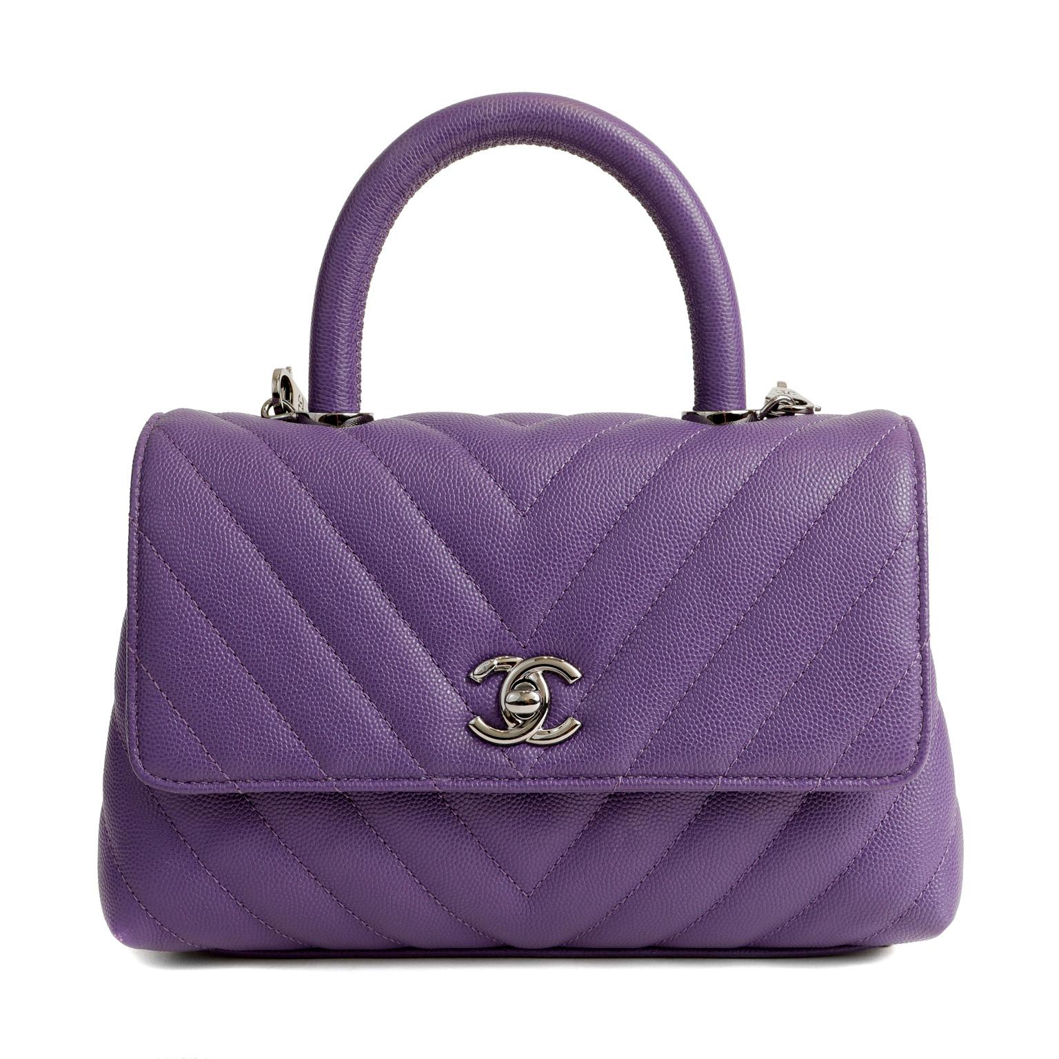 This authentic Chanel Purple Caviar Chevron Mini Coco Handle Bag is in pristine condition.  The Coco Handle is a distinctively different flap bag silhouette; a must have addition to any collection.
Exquisite purple caviar leather is textured and