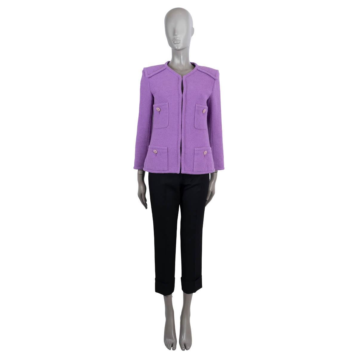 Veste en tweed sans col, 100% authentique de Chanel, en coton violet (100%). Il présente une légère encolure en V, quatre poches plaquées boutonnées et des empiècements sur les épaules. Il se ferme à l'aide de crochets dissimulés sur le devant et