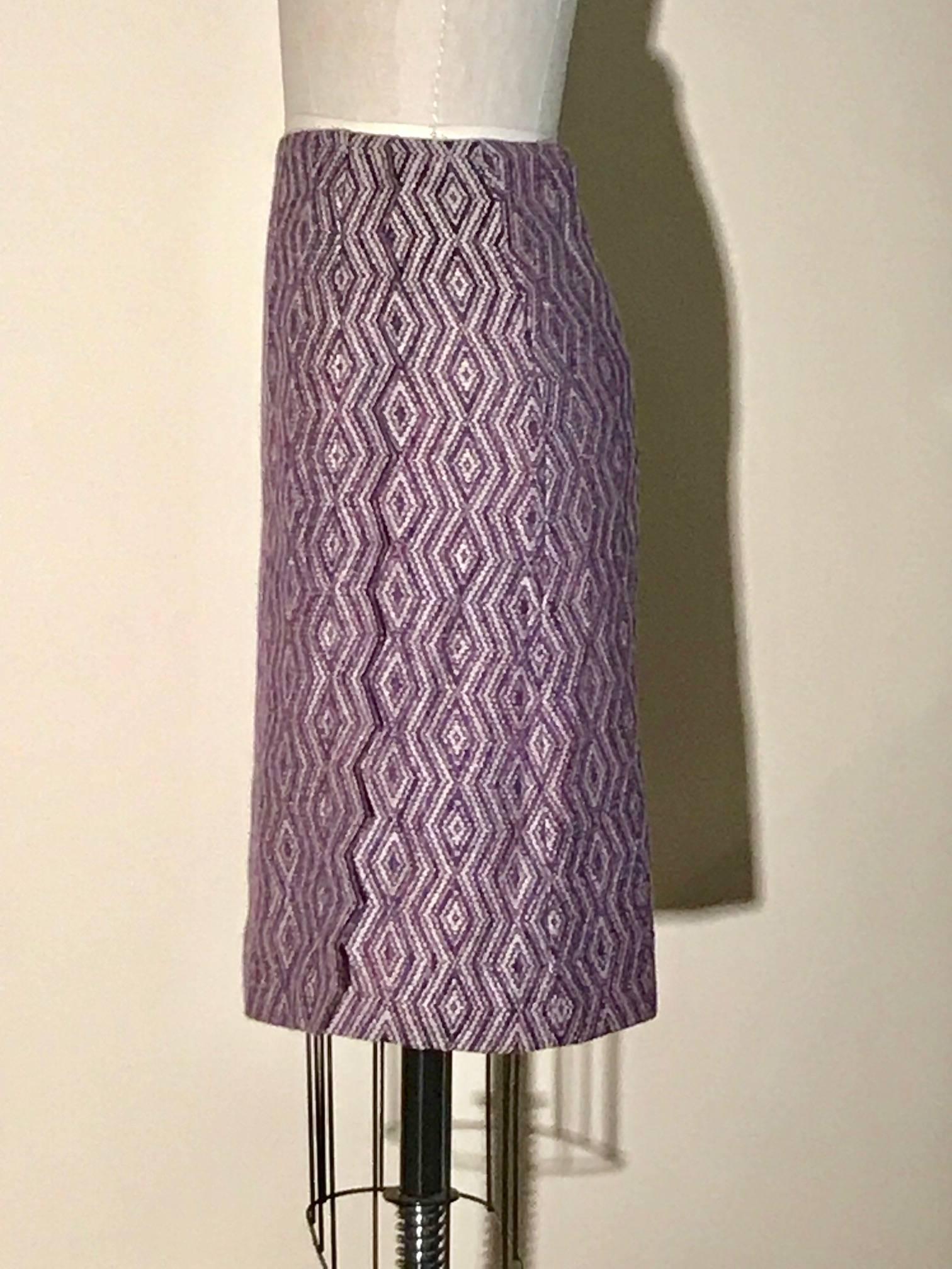 Chanel purple diamond weave pencil skirt with a strip of zig zag cut trim at front and back side. Purple printed silk with clover pattern from lining peeks out from beneath the zig zag cut trim. Fastens with zip and hook and eye at side-back. 

74%