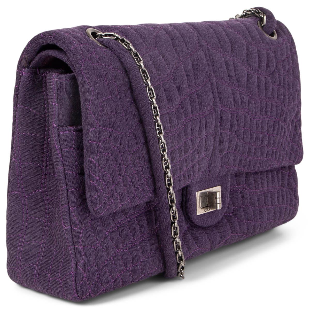 100% authentic Chanel 2.55 Reissue 226 Double Flap Bag in deep purple croc embroidered jersey fabric and is provided with gold-tone hardware. It features a turn-lock closure and a chain-jersey shoulder strap. Lined in deep purple nylon fabric with