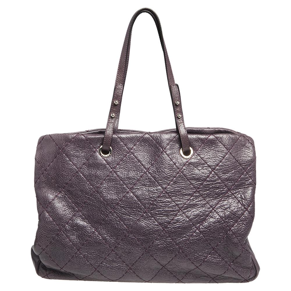 Brilliantly designed to assist you with all your daily needs, this stylish Chanel tote comes crafted from quilted glazed leather in a purple shade. It features spacious compartments for easy organization and is aided by silver-tone hardware. The bag