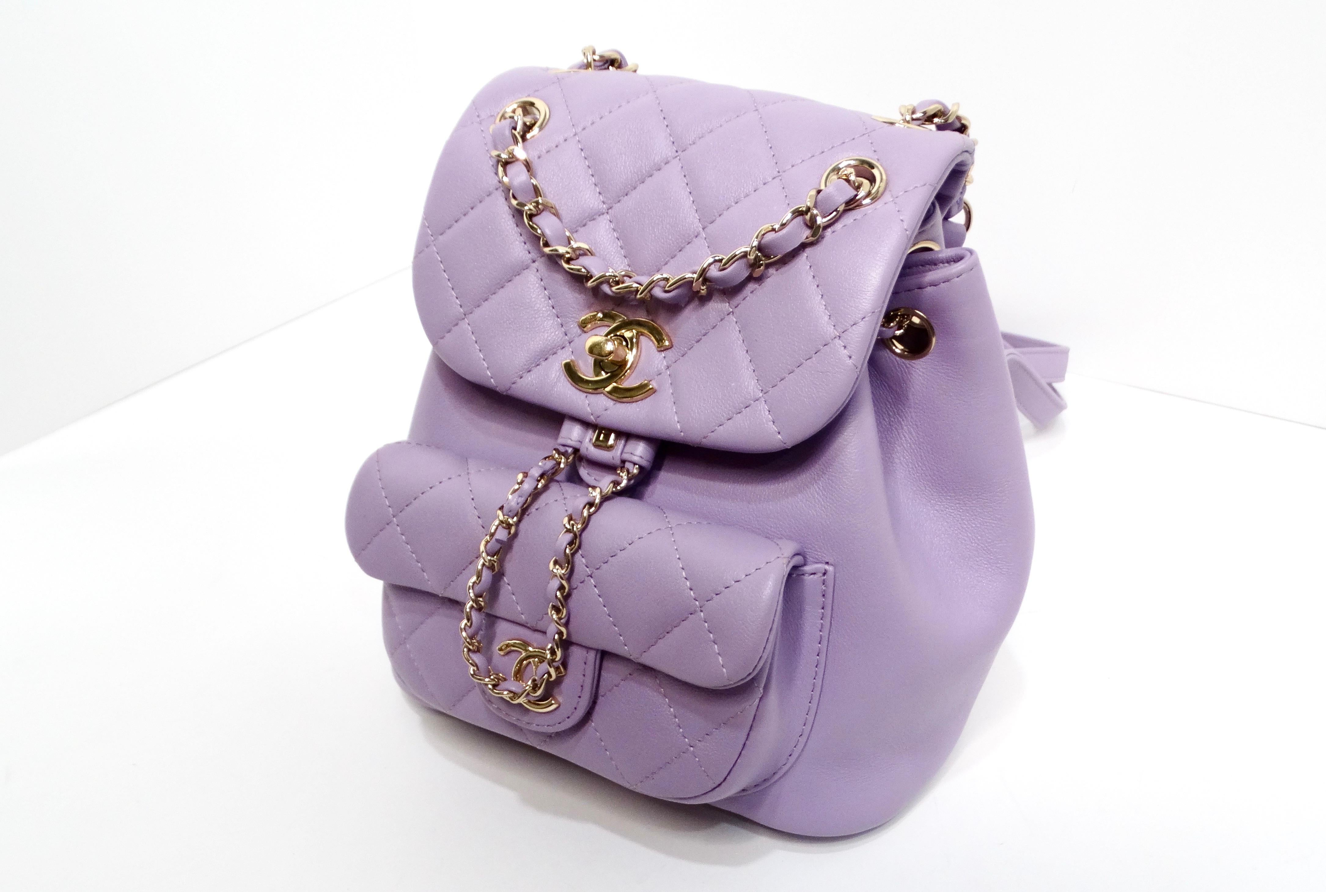 Introducing the Chanel Purple Quilted Lambskin Duma Backpack, a stunning blend of elegance and functionality that embodies luxury craftsmanship. This mini-sized backpack showcases an exquisite purple quilted lambskin leather exterior, adorned with