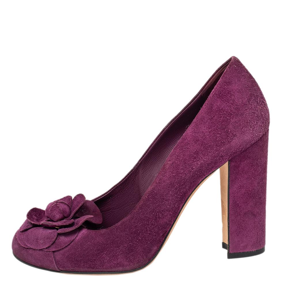 Create an aura of elegance with these stunning Chanel pumps for women. These pumps are crafted from suede in a purple shade. The pair flaunts the signature camellia detailing on the uppers, leather-lined insoles, round toes, and block heels. These