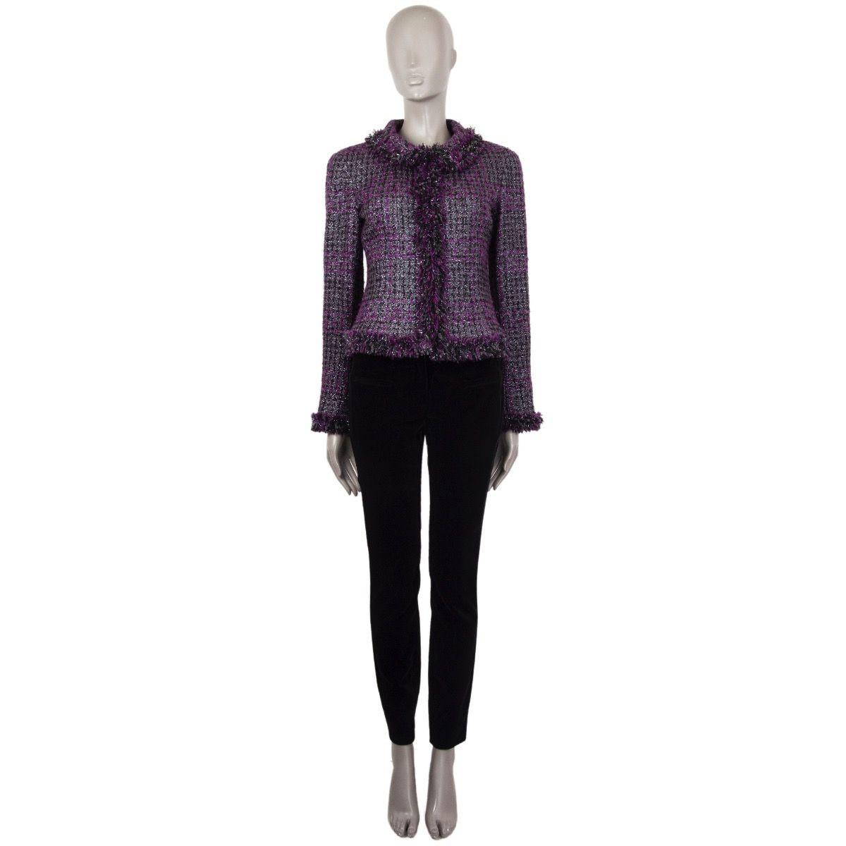 Chanel fringed lurex tweed blazer in black, silver and purple wool (95%), polyester (3%), and nylon (2%). With flat collar and signature change around the inside of the hemline. Closes with concealed hooks on the front. Lined in black camelia-print