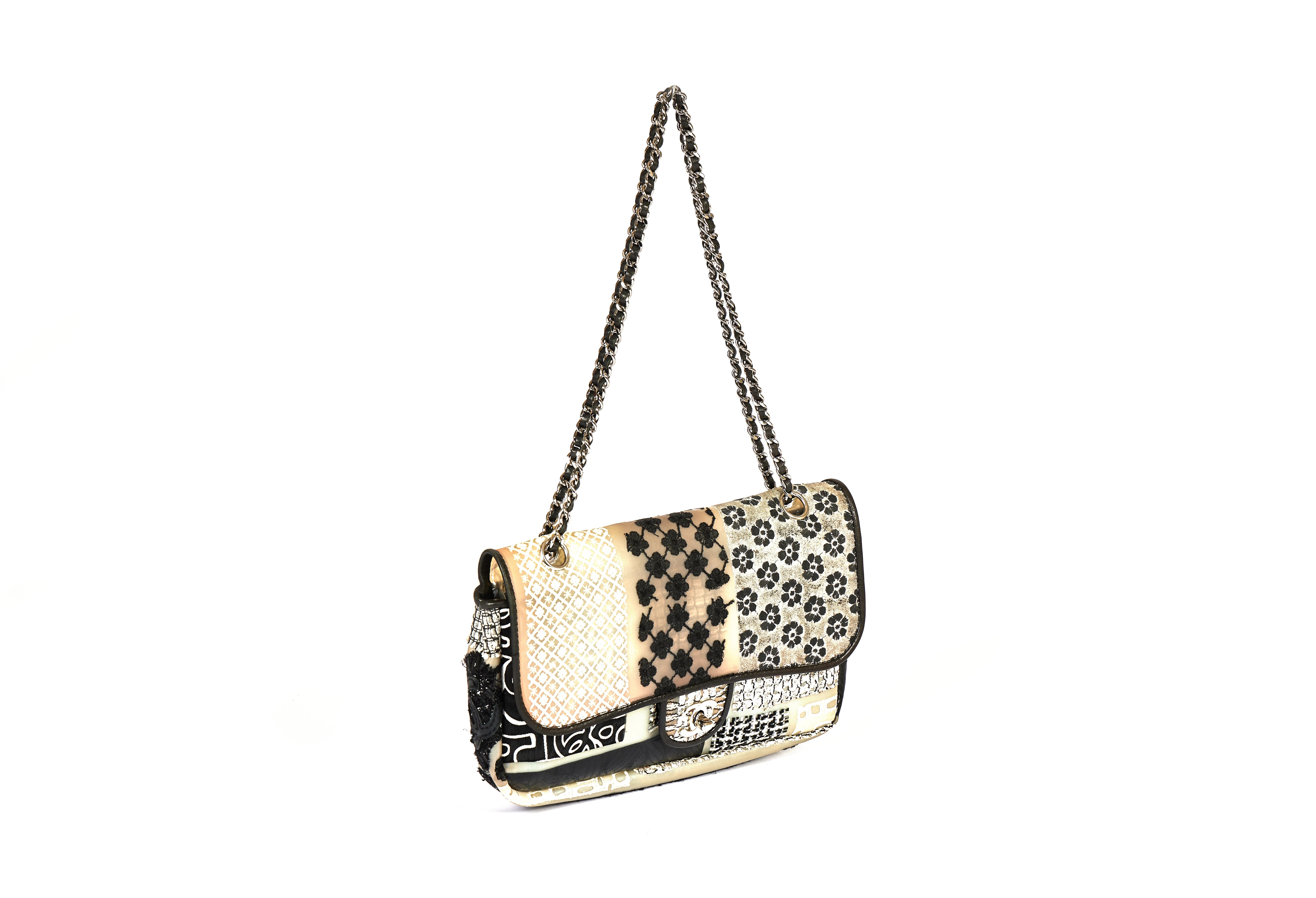 This single flip Chanel bag is super fun. It's made out off PVC and has different floral patterns which are stitched into the material. It is trimmed by lambskin leather and comes with a silver chain. The shoulder drop is 10 inches and you can also