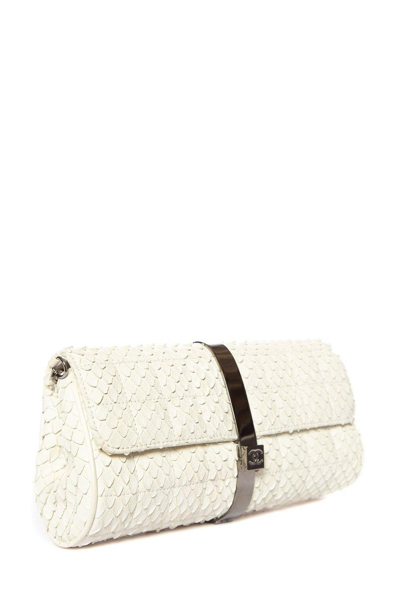 This Chanel clutch comes in an exotic cream python texture. The clutch is accented by a gunmetal gray chain and wrap around metal detail locking in the front with the classic Chanel logo. 

This item is in excellent condition with minor scratching
