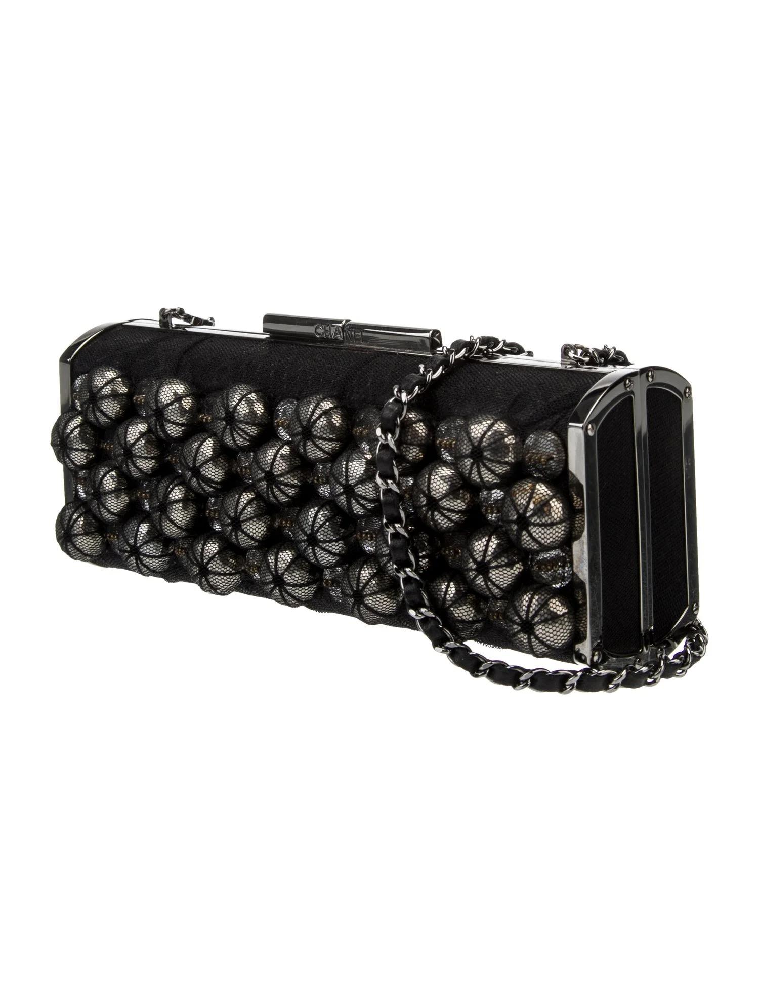 Pochette noire Chanel
Collection 2006-2008
Python noir
Logo CC imbriqué et accents en mailles de chaîne
Quincaillerie argentée
Bandoulière à maillons de chaîne
Accents en maille
Doublure en cuir
Fermeture à bouton-poussoir sur le dessus

Fabriqué en