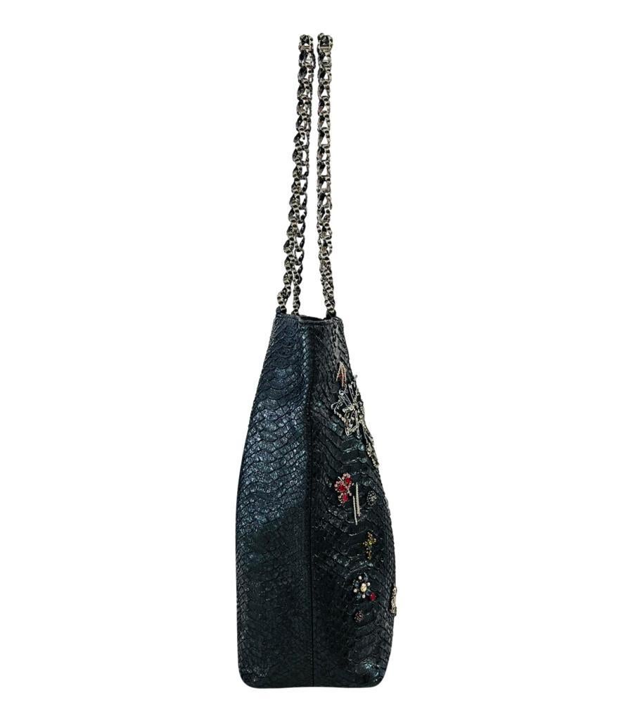 Rare Item - Chanel Python Skin Crystal Embellished Tote Bag

Black tote bag crafted in python skin and adorned with multicoloured crystals and pins design.

Featuring ruthenium hardware, signature chain and leather shoulder strap and magnetic top