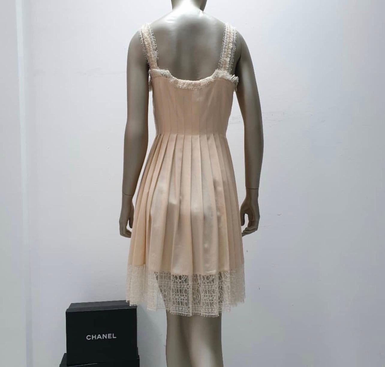 Chanel Pre-Fall 2013
Chanel pleated dress with lace and straps.
Sz.38fr, 
100%silk
Salmon pink color. W
Very good condition.
Front opening with four enamel jewelry buttons. 
Unlined and wrap skirt. 
Very beautiful lace details and hidden transparent