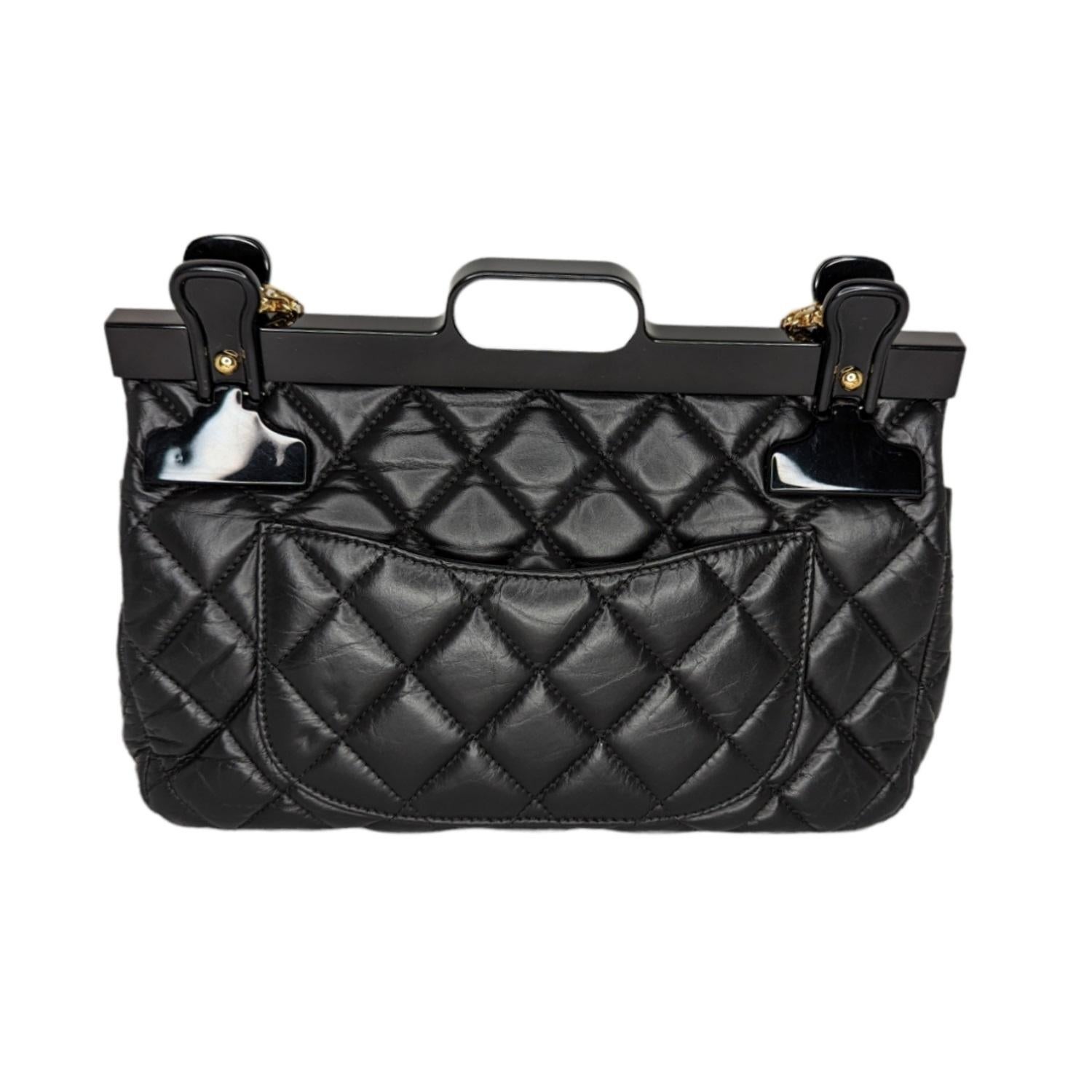 Black diamond-quilted aged calfskin Chanel 2.55 Reissue 225 Hanger Flap bag with gold-tone hardware, single chain-link shoulder strap, single patch pocket at back, acrylic hanger accent with interlocking CC adornment at top, burgundy leather lining,