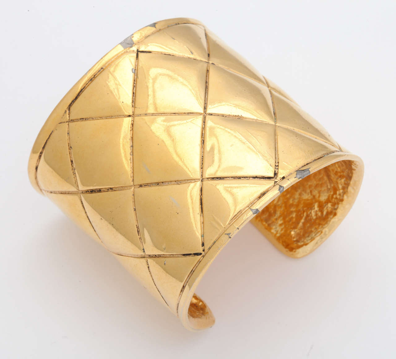 Chanel gold tone bangle bracelet with quilted details, it has a small CC logo on the side.
Signed Chanel made in France.