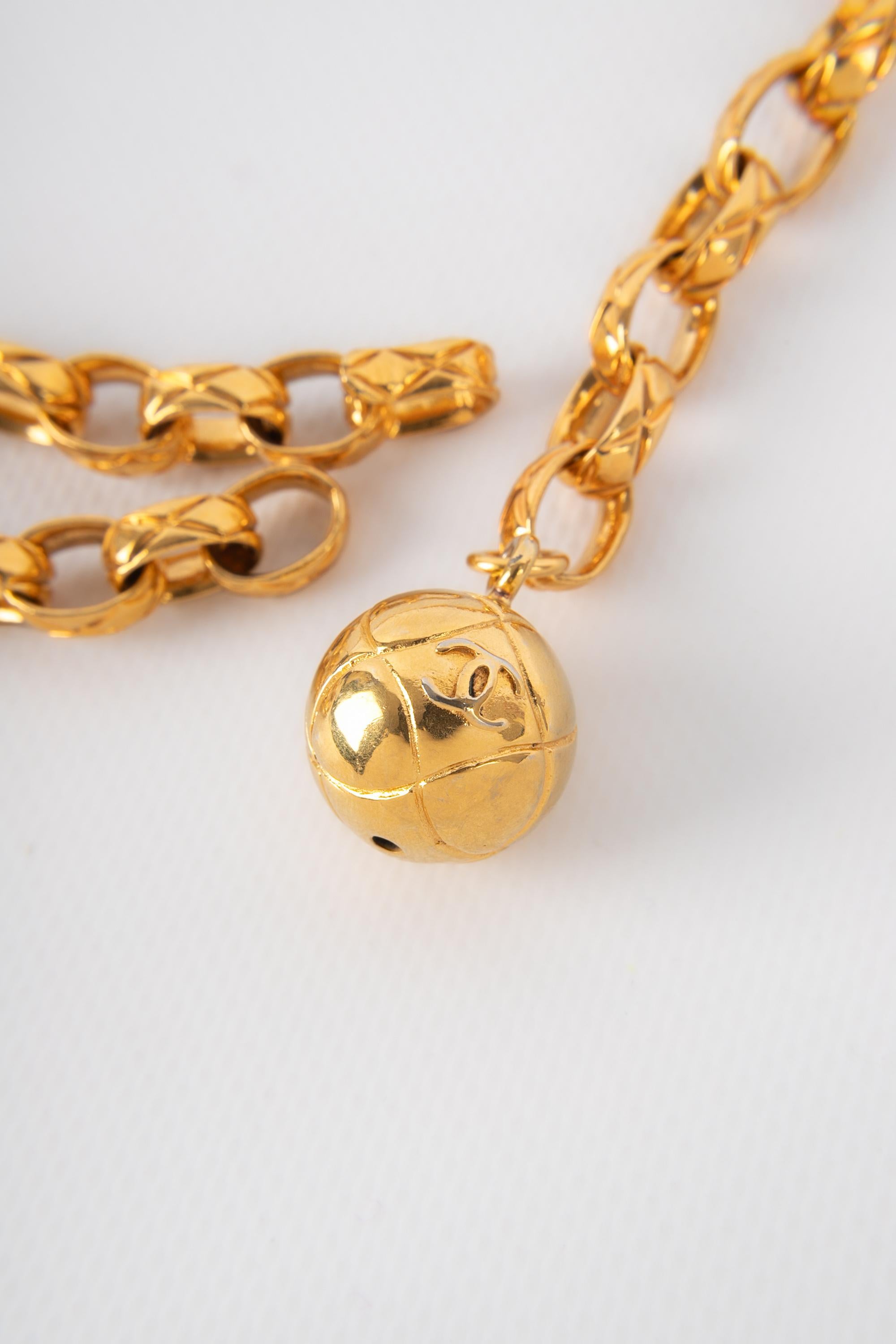 CHANEL - (Made in France) Goldener, gesteppter Metallgürtel mit einem kugelförmigen Charme.

Bedingung:
Sehr guter Zustand

Abmessungen:
Länge: 80 cm

CCB26